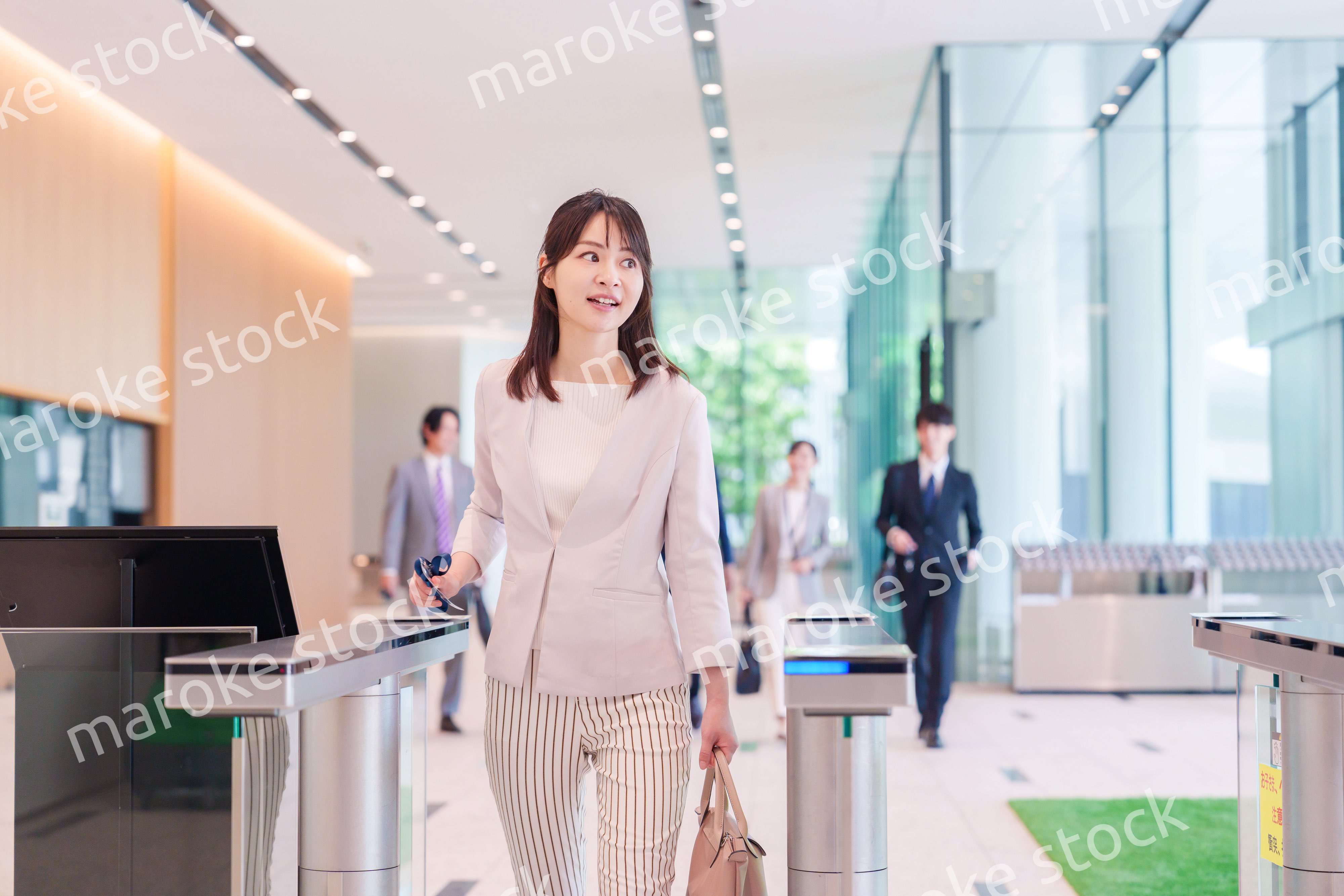 オフィスのセキュリティゲートを通るビジネスウーマン