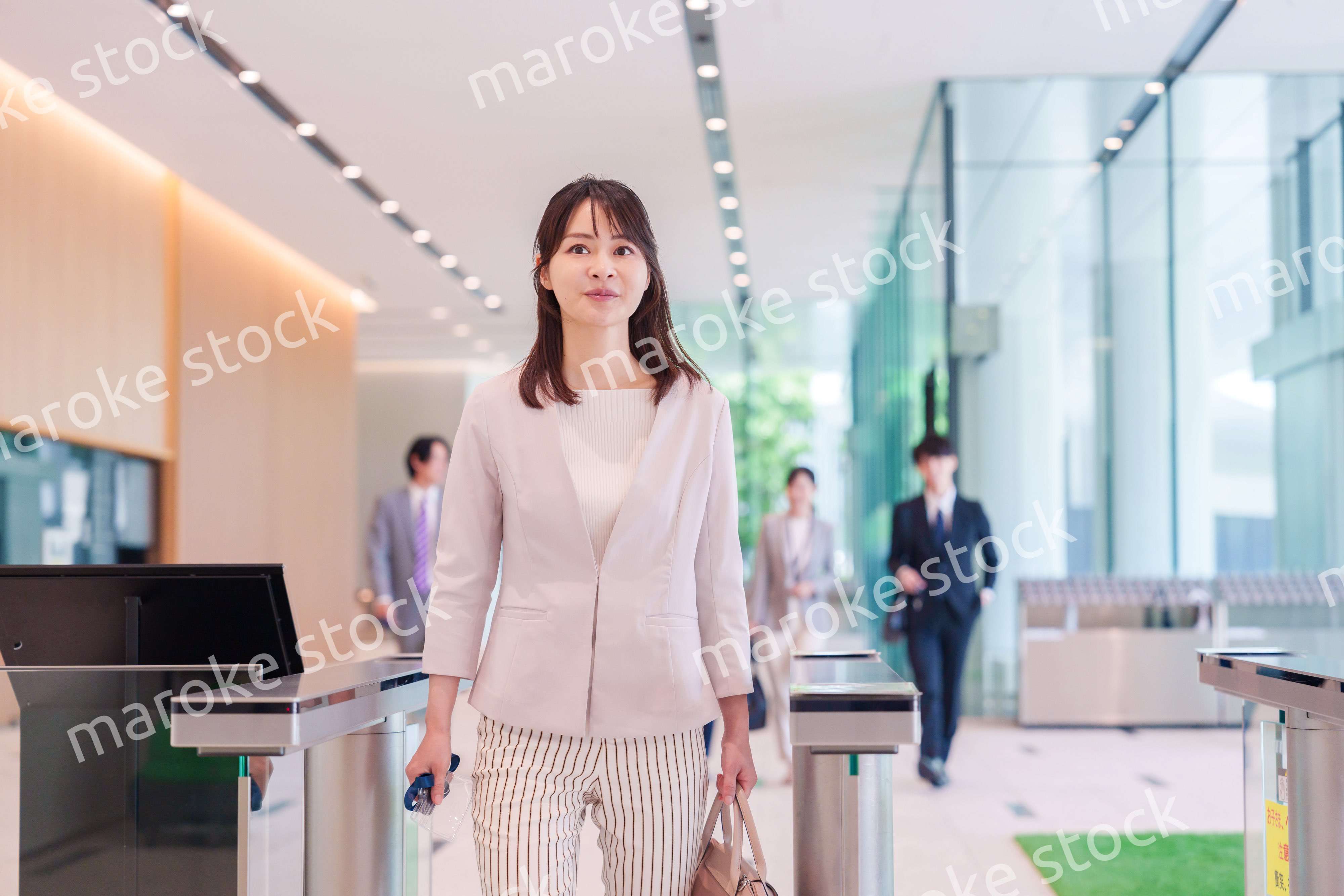 オフィスのセキュリティゲートを通るビジネスウーマン