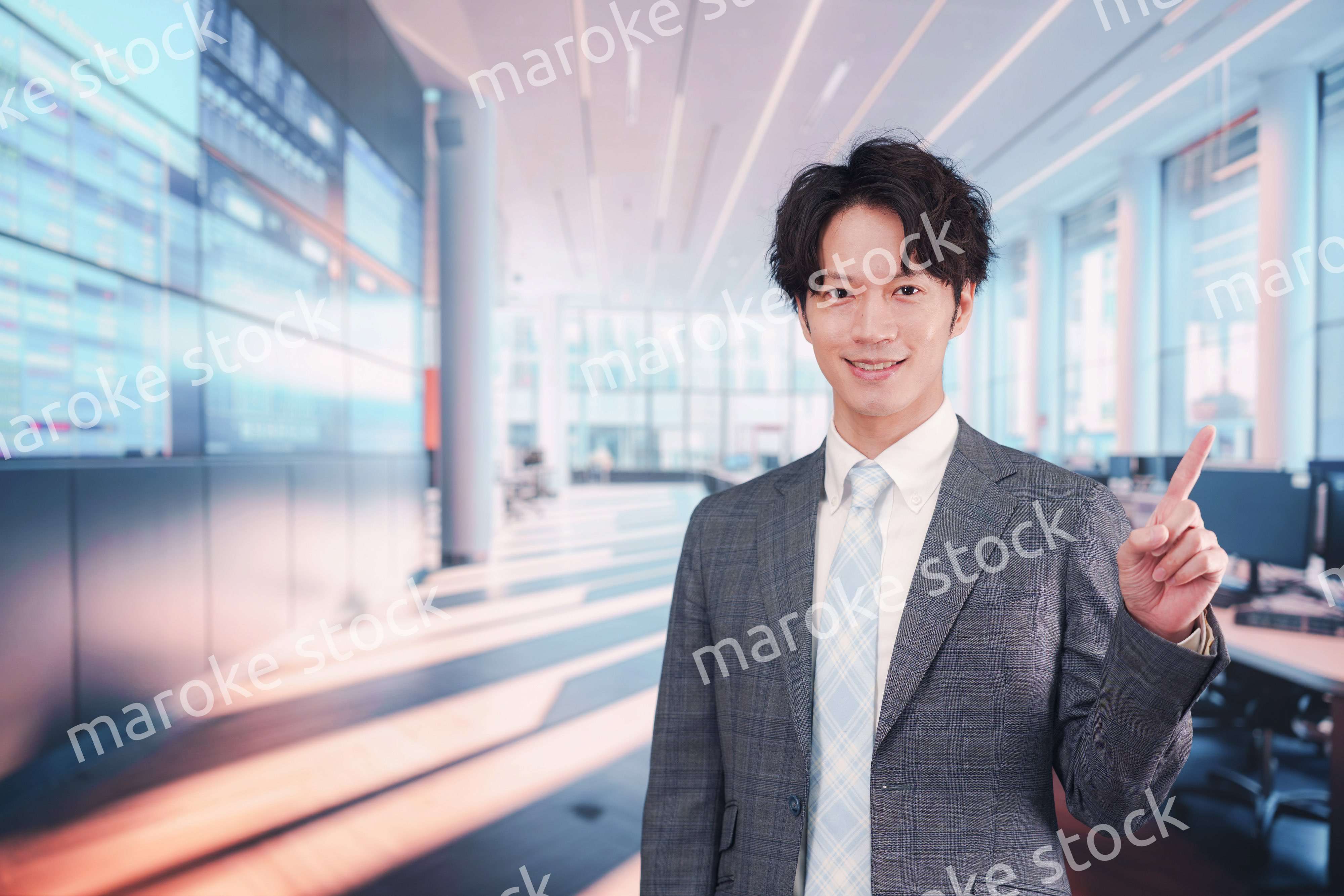 株価ボードの前に立つスーツを着たビジネスマン