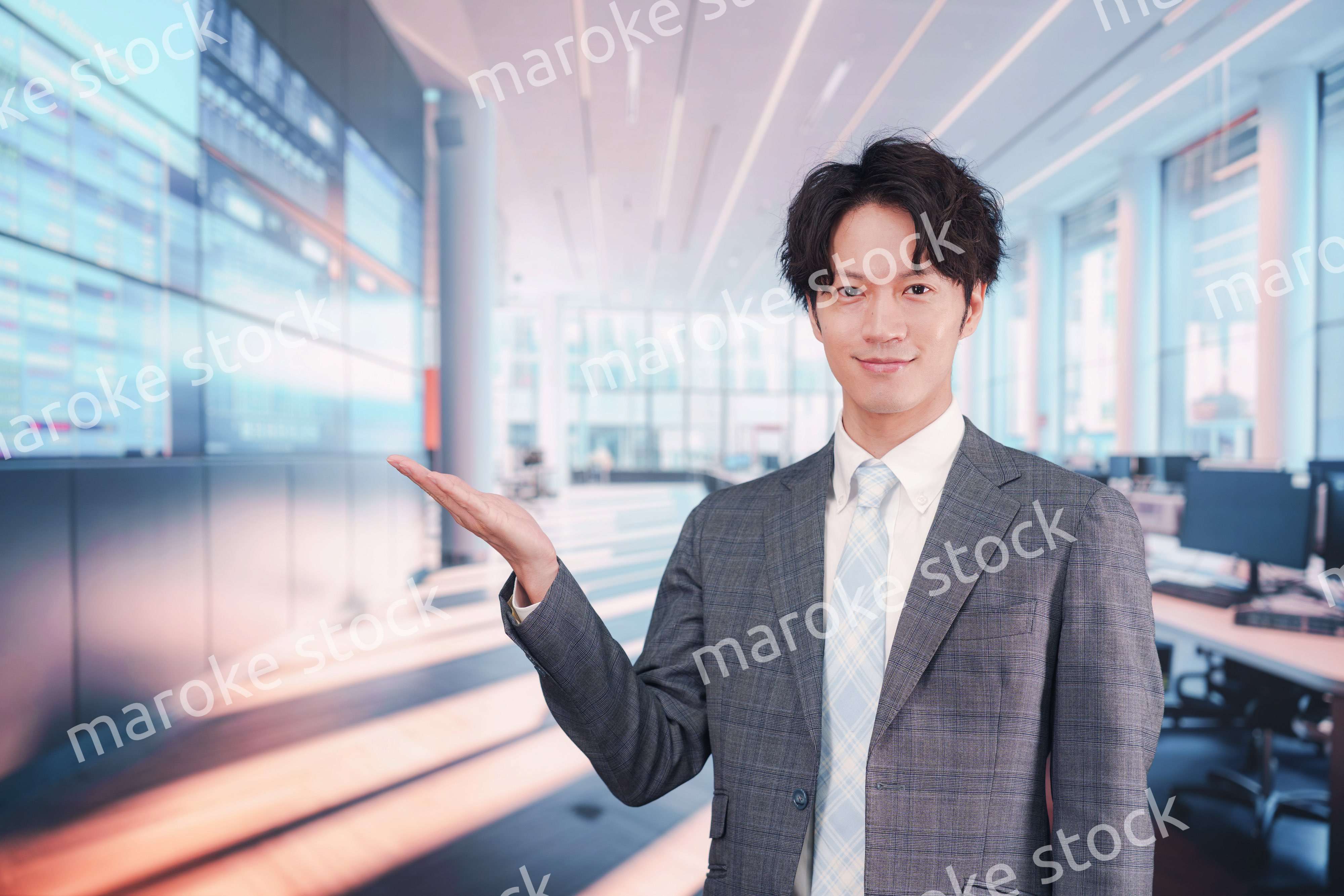 株価ボードの前に立つスーツを着たビジネスマン