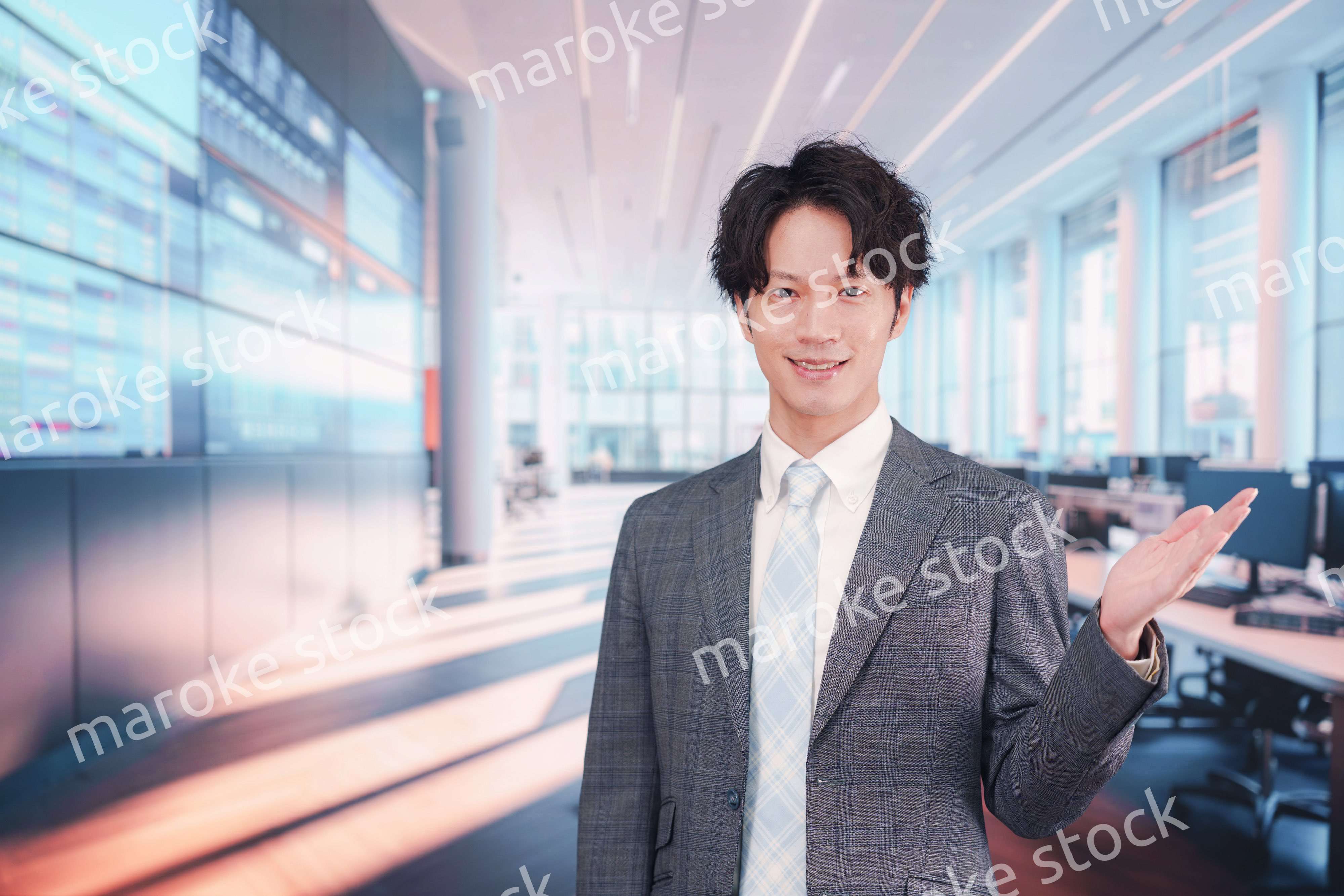 株価ボードの前に立つスーツを着たビジネスマン