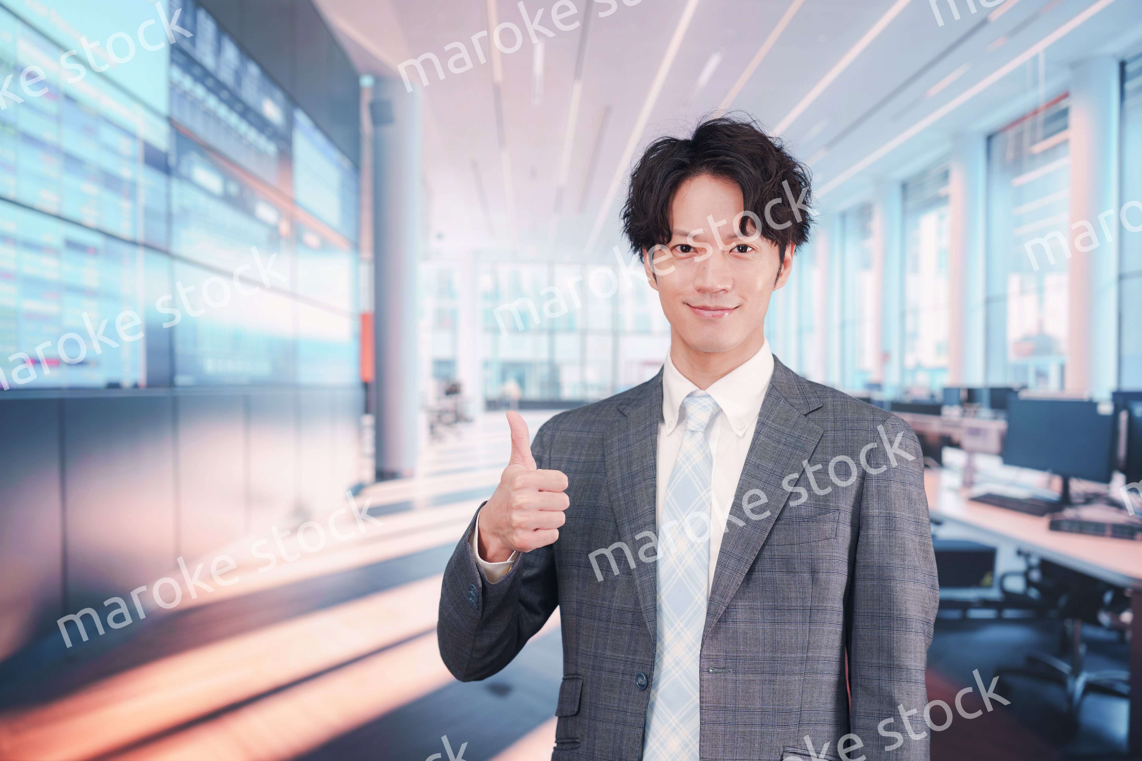 株価ボードの前に立つスーツを着たビジネスマン