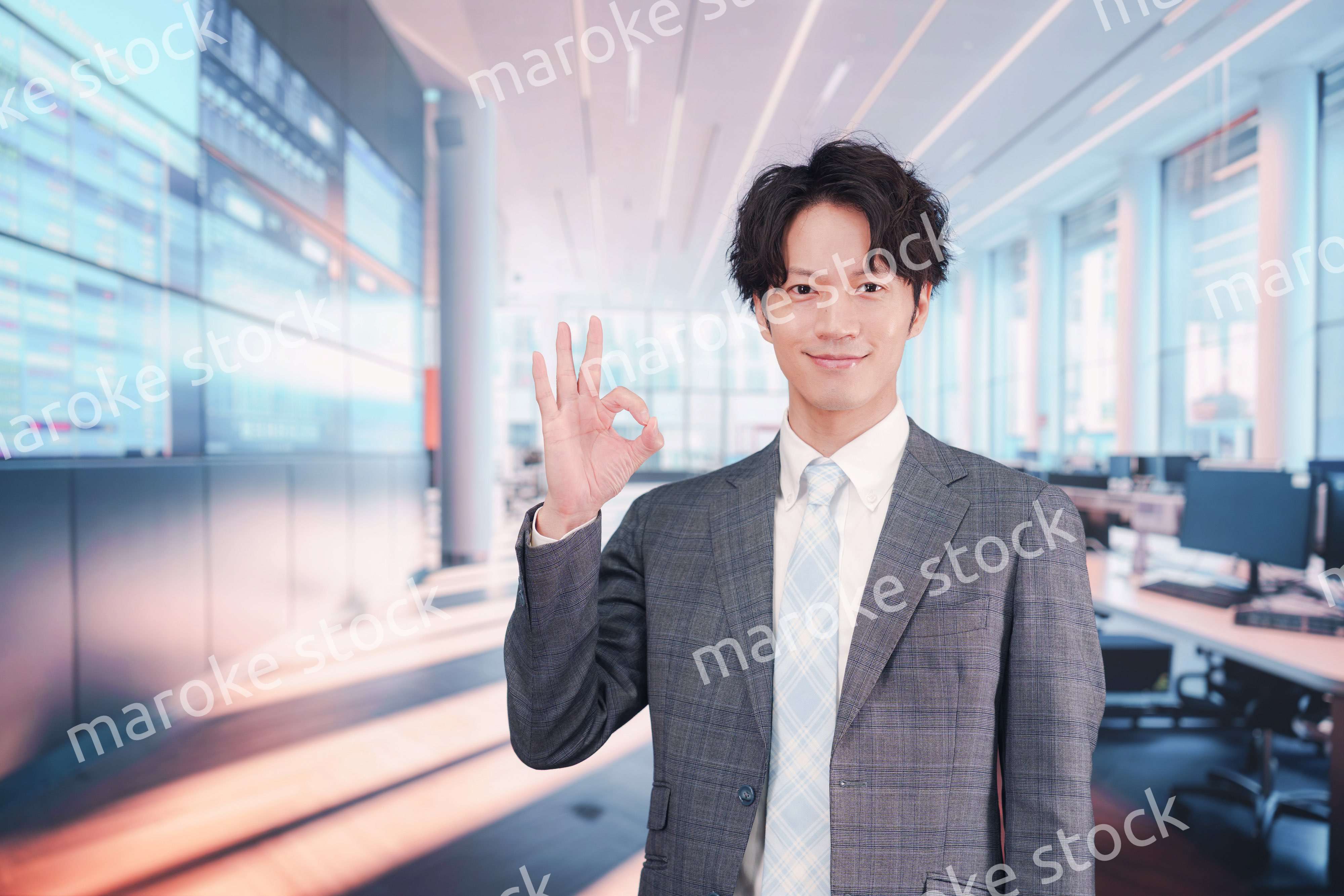 株価ボードの前に立つスーツを着たビジネスマン