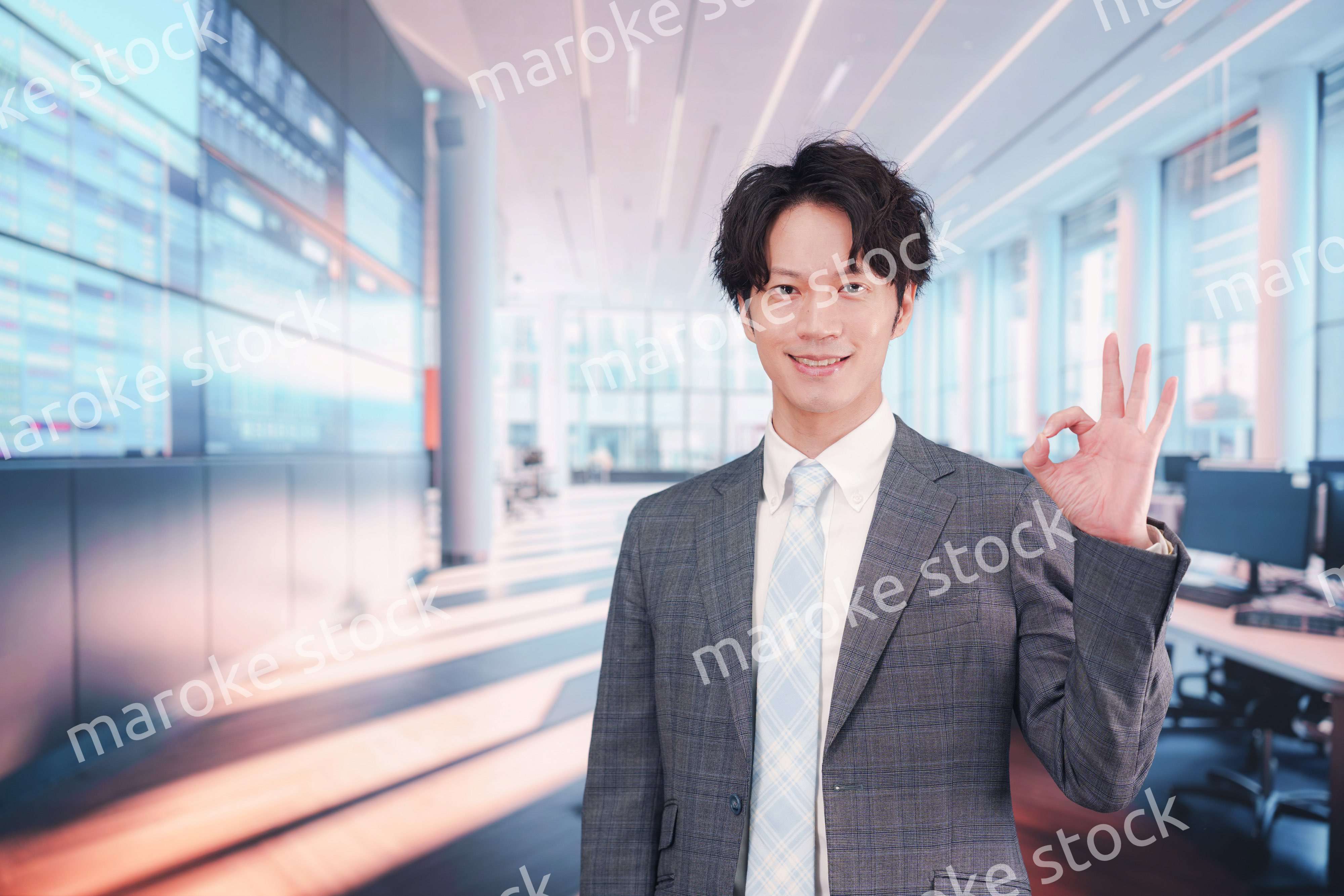 株価ボードの前に立つスーツを着たビジネスマン