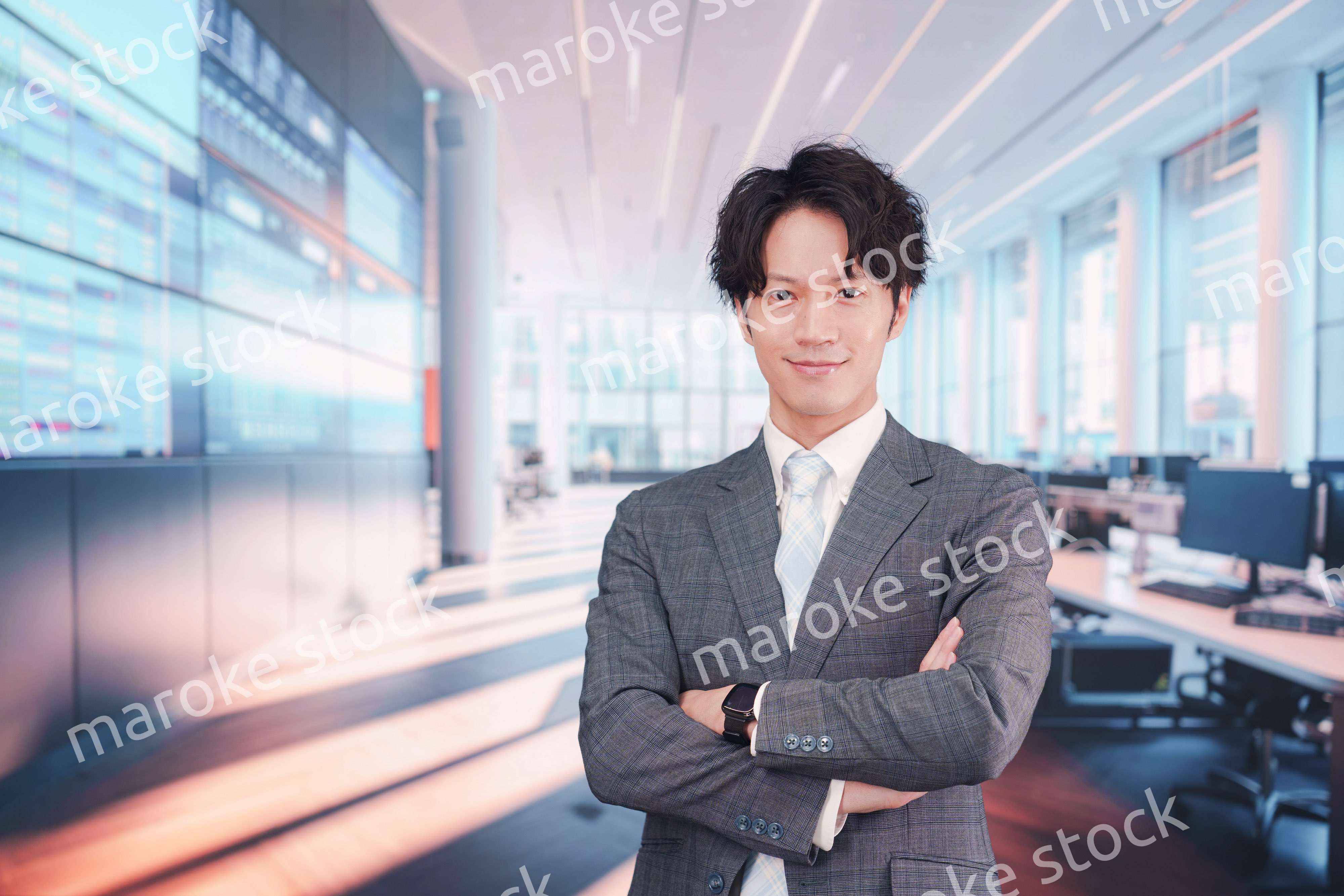 株価ボードの前に立つスーツを着たビジネスマン