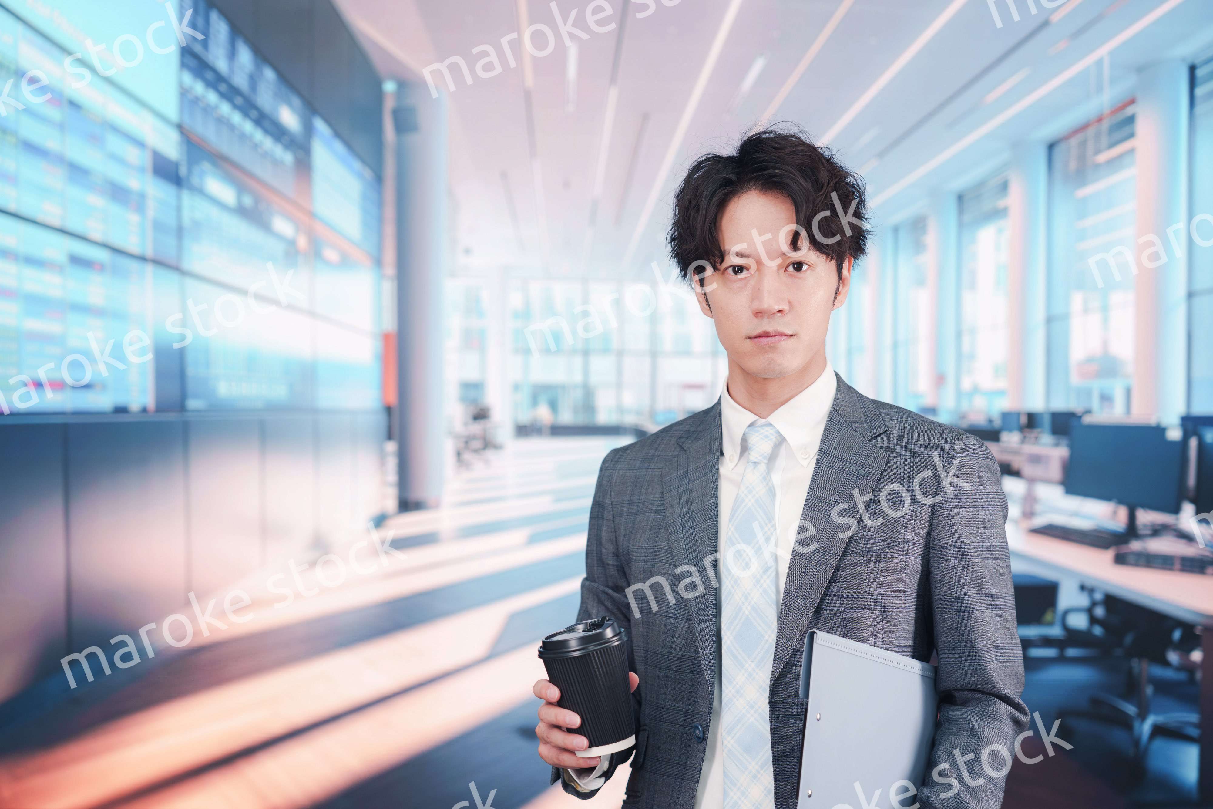 オフィスで紙カップのコーヒーを持って歩くビジネスマン