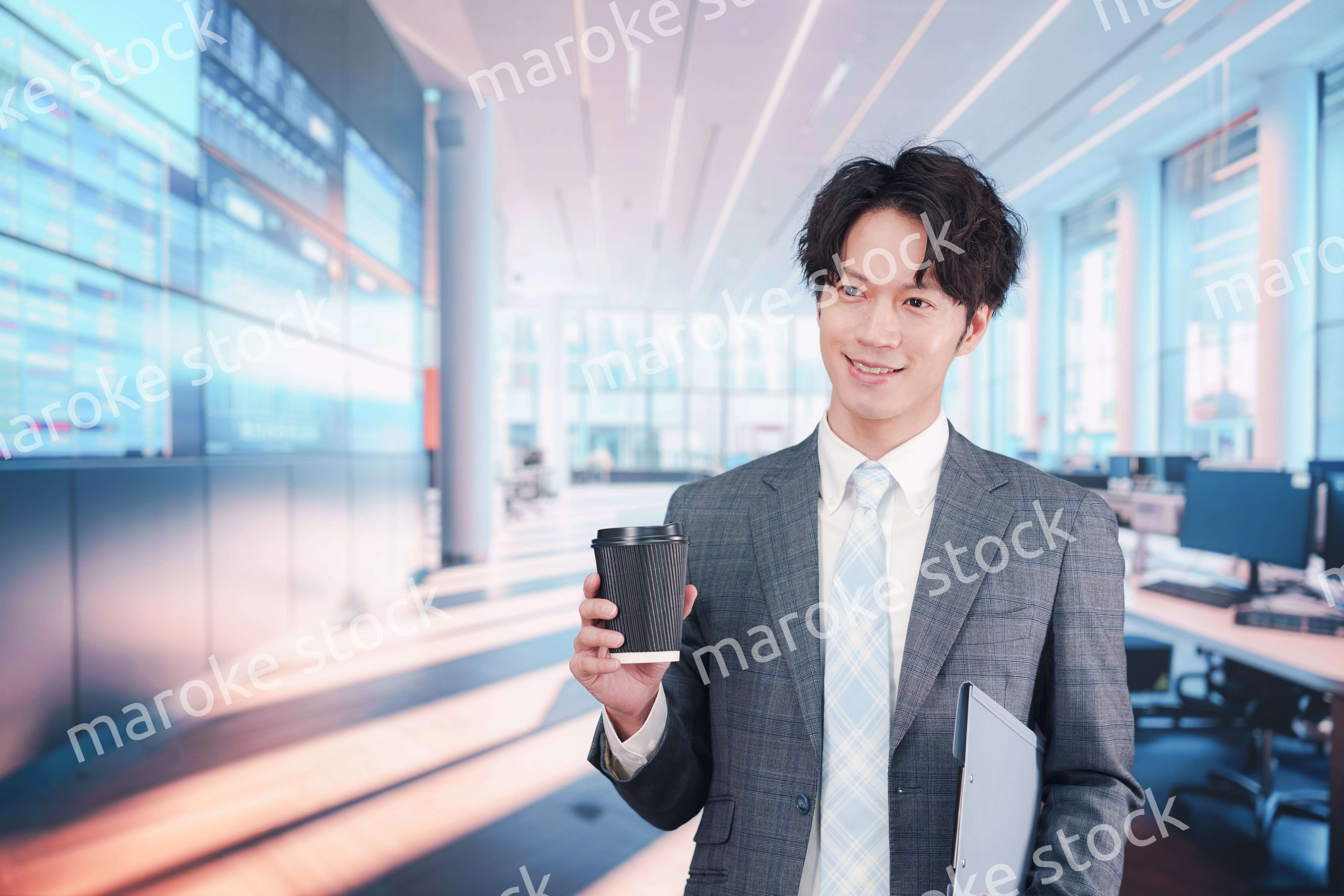 オフィスで紙カップのコーヒーを持って歩くビジネスマン