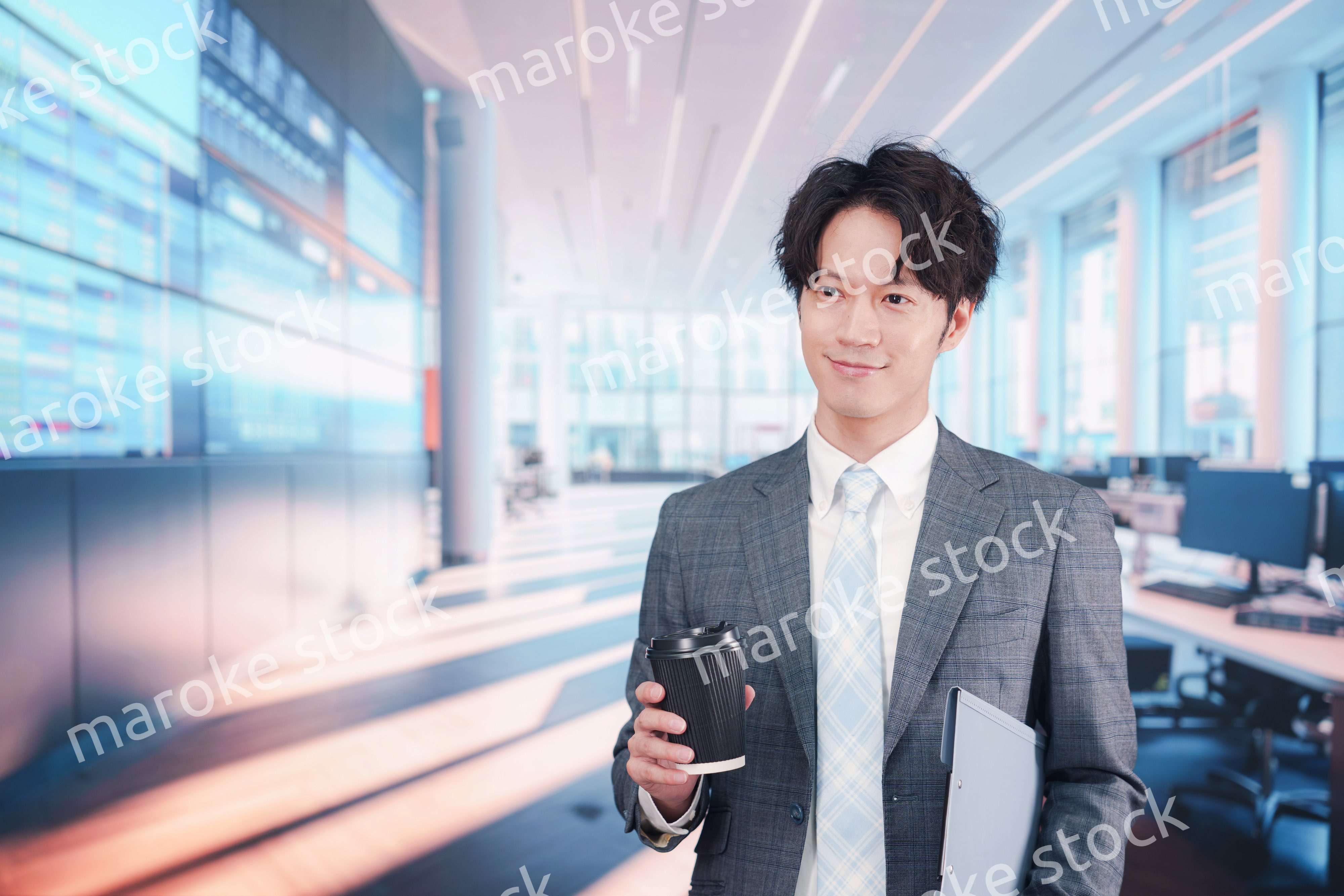 オフィスで紙カップのコーヒーを持って歩くビジネスマン