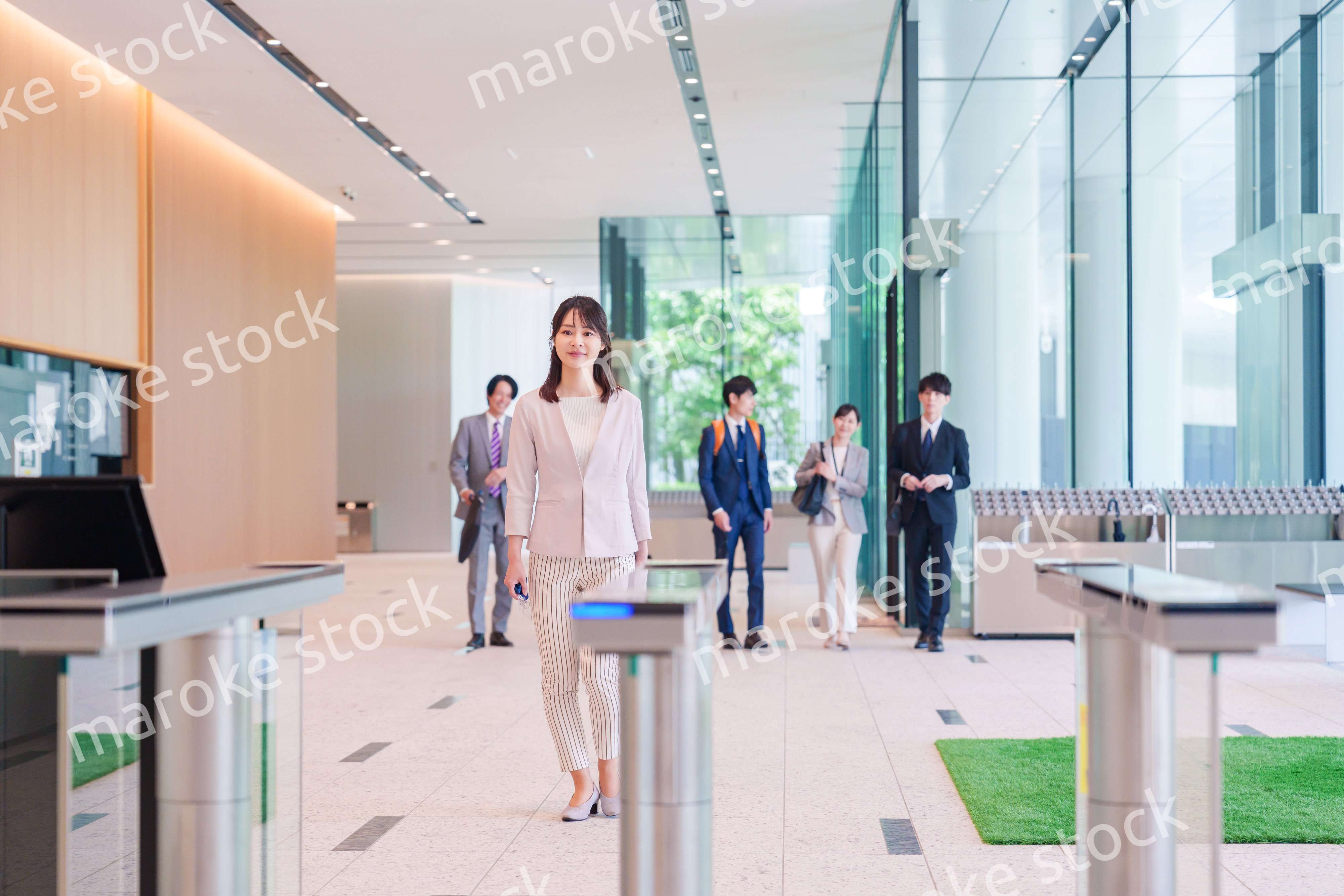 オフィスのセキュリティゲートを通るビジネスウーマン