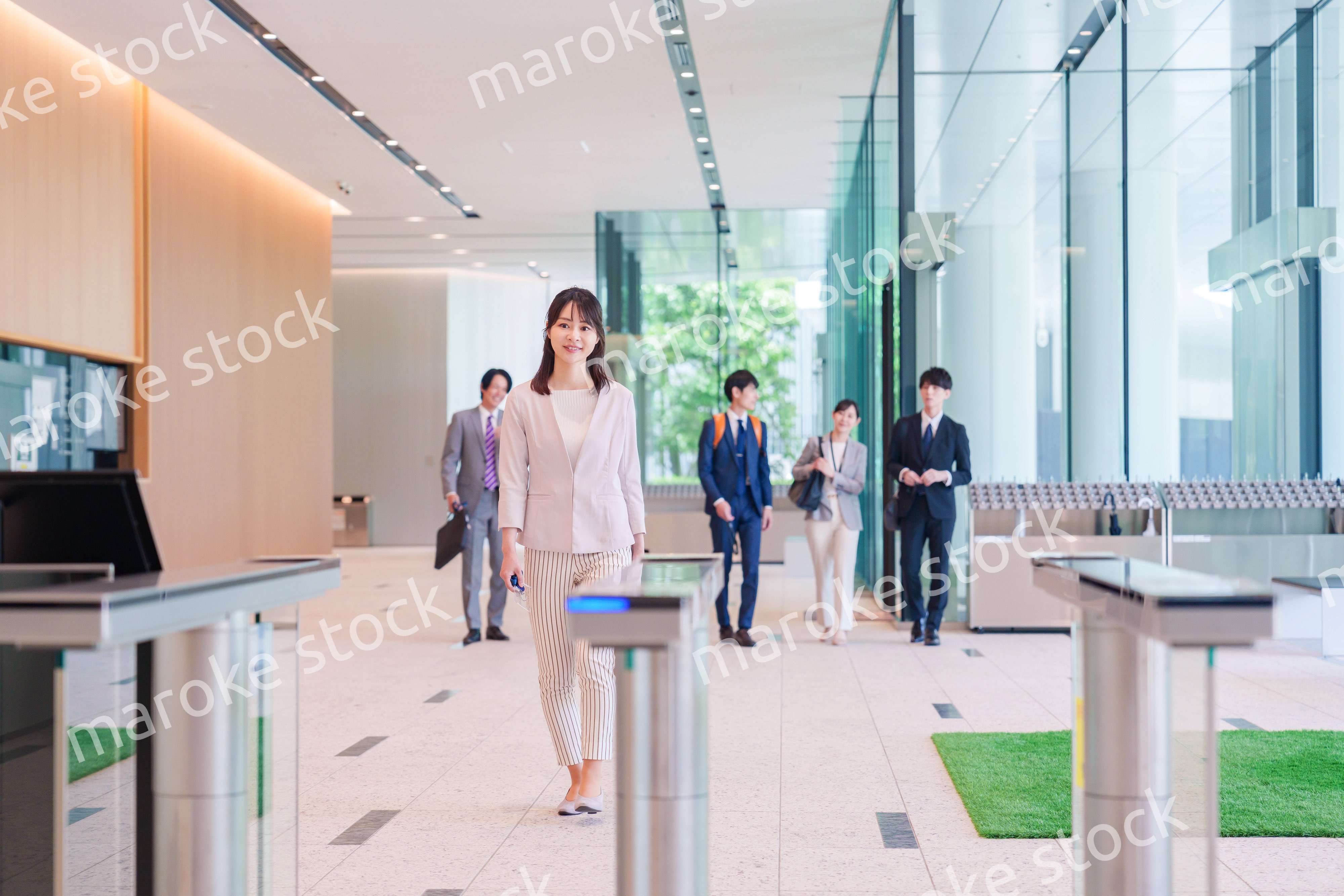 オフィスのセキュリティゲートを通るビジネスウーマン