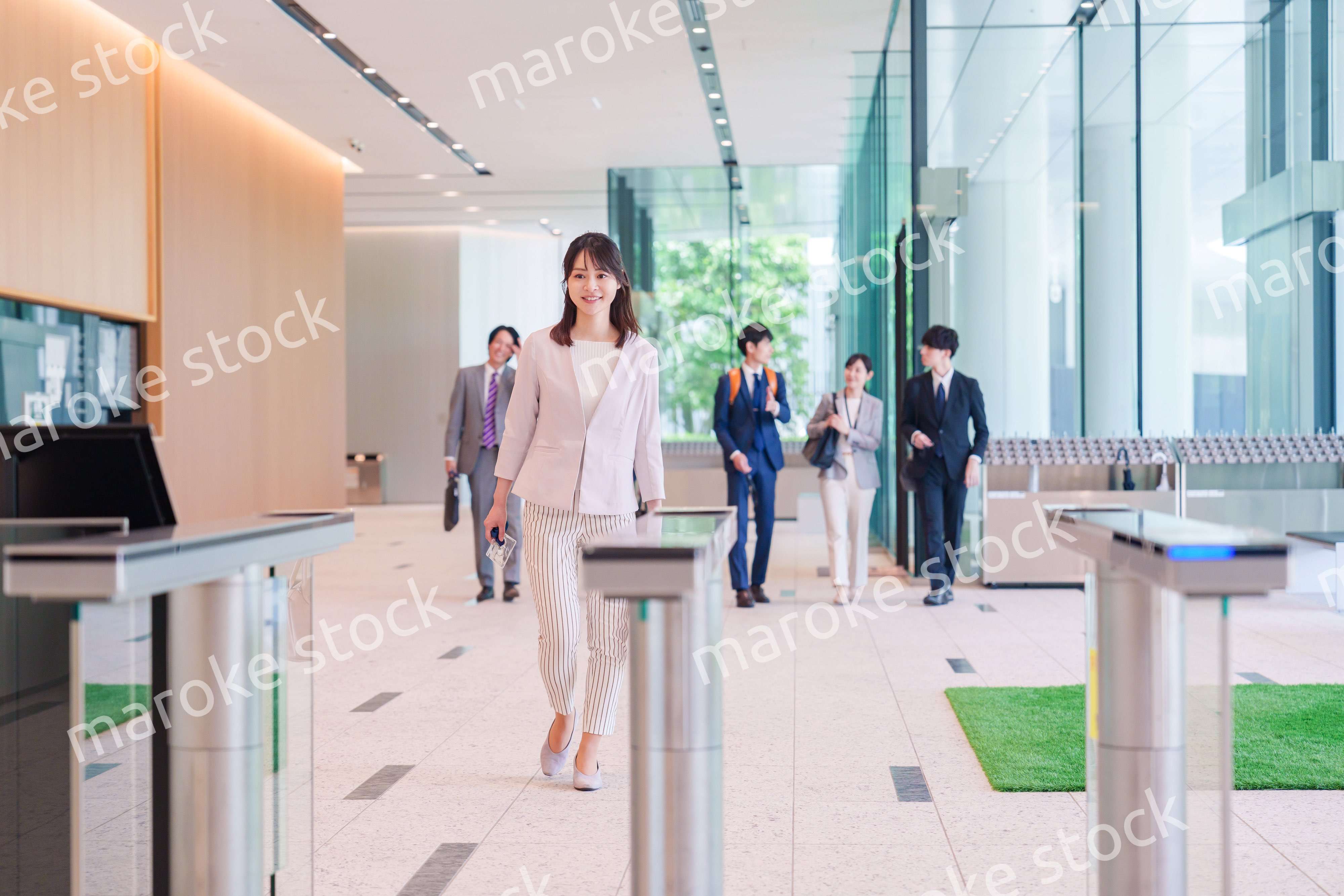 オフィスのセキュリティゲートを通るビジネスウーマン