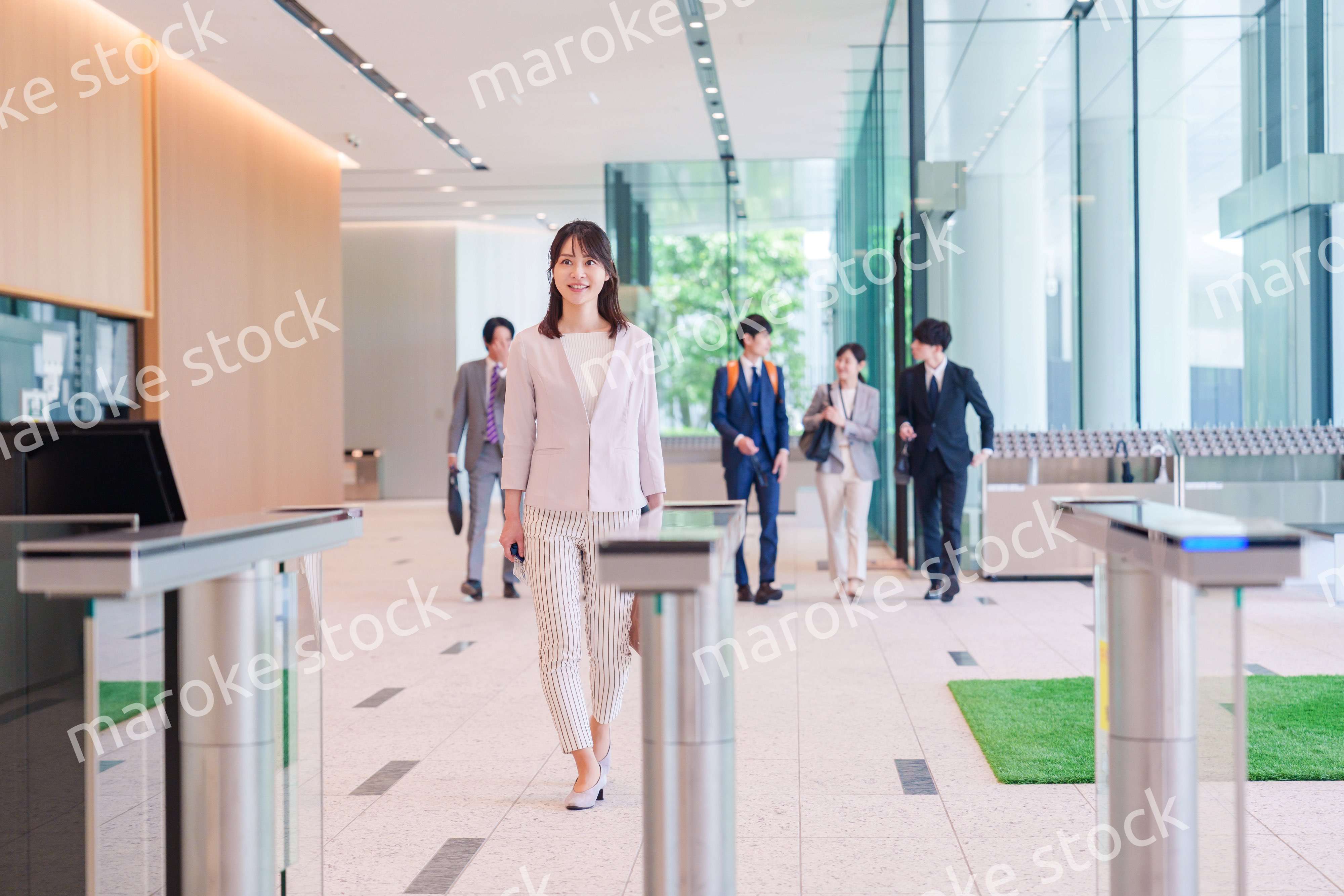 オフィスのセキュリティゲートを通るビジネスウーマン