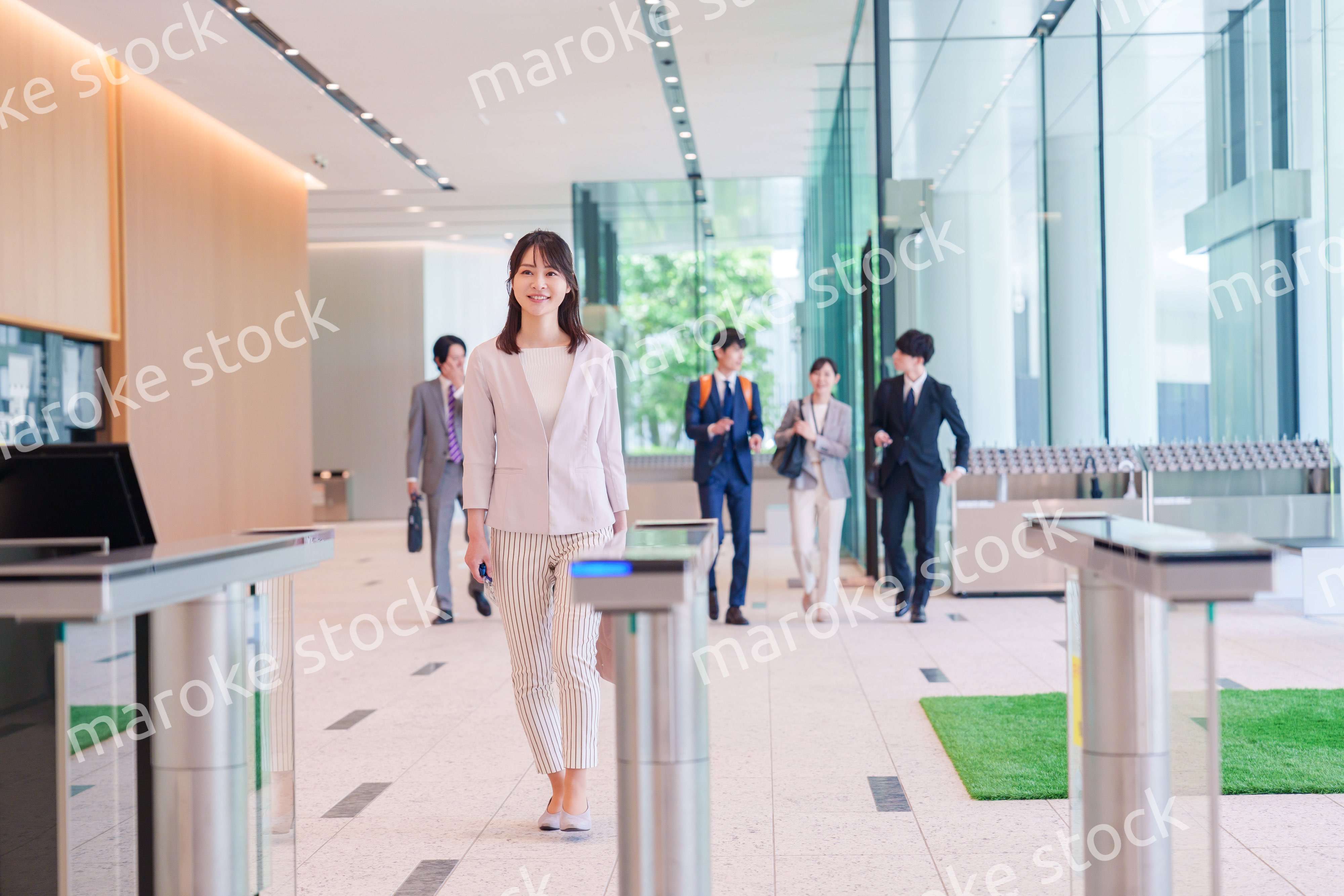 オフィスのセキュリティゲートを通るビジネスウーマン