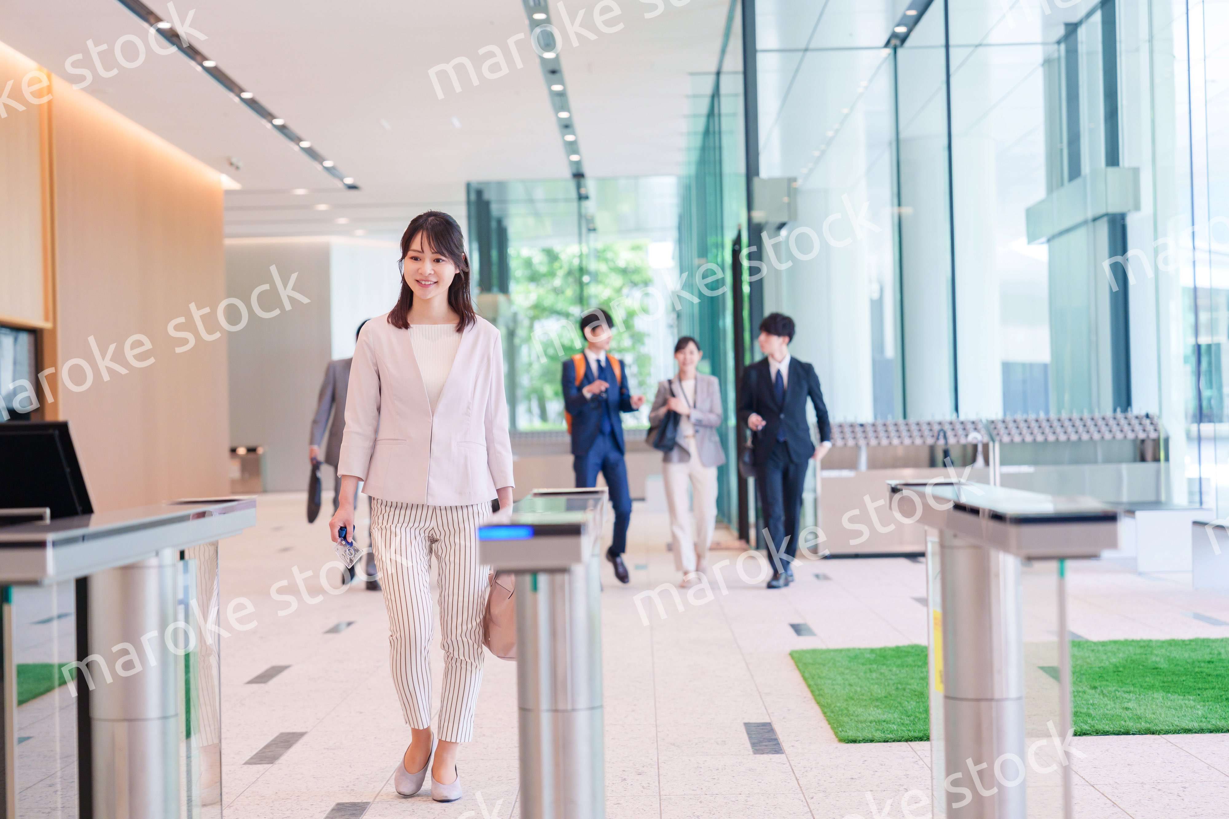 オフィスのセキュリティゲートを通るビジネスウーマン