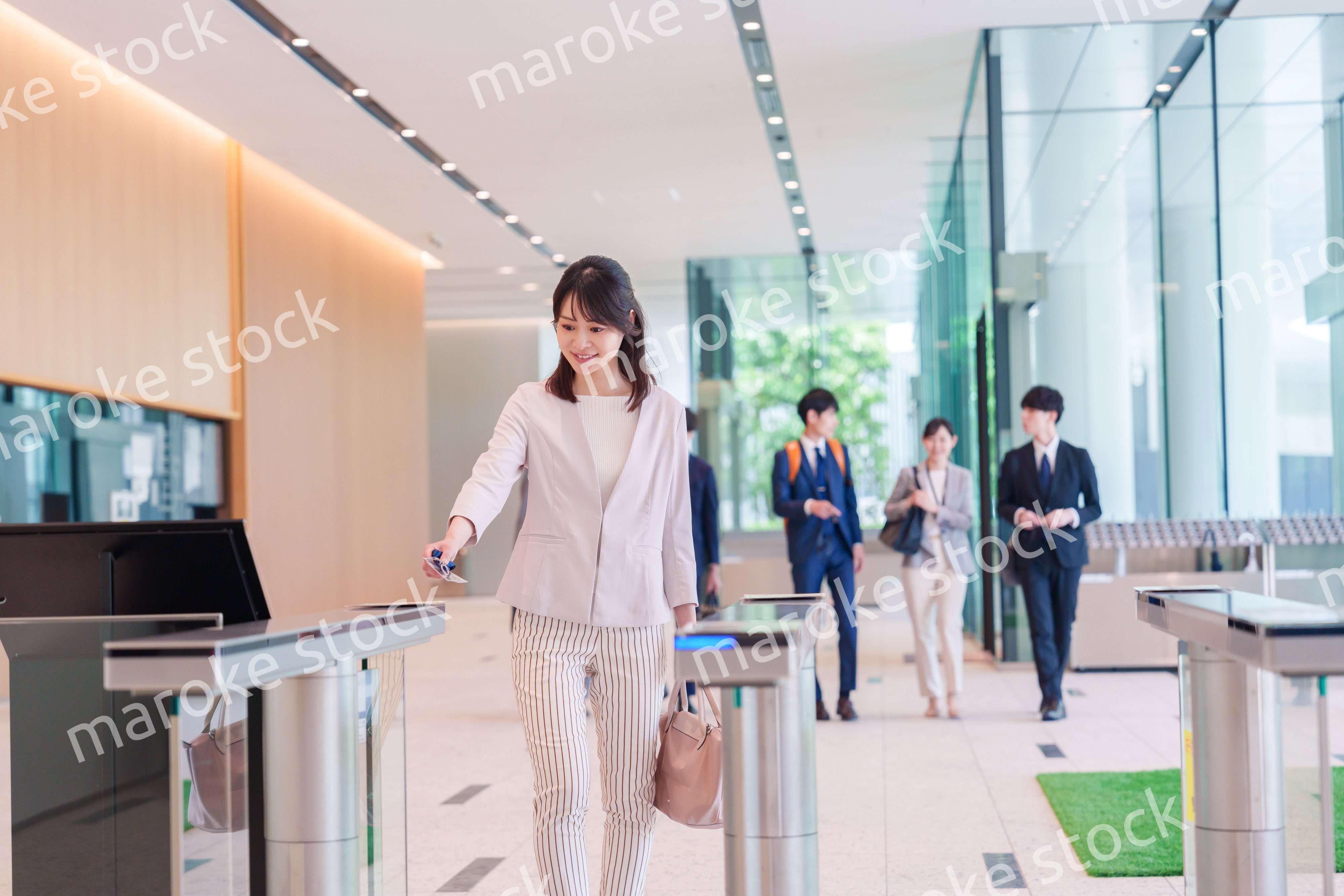オフィスのセキュリティゲートを通るビジネスウーマン