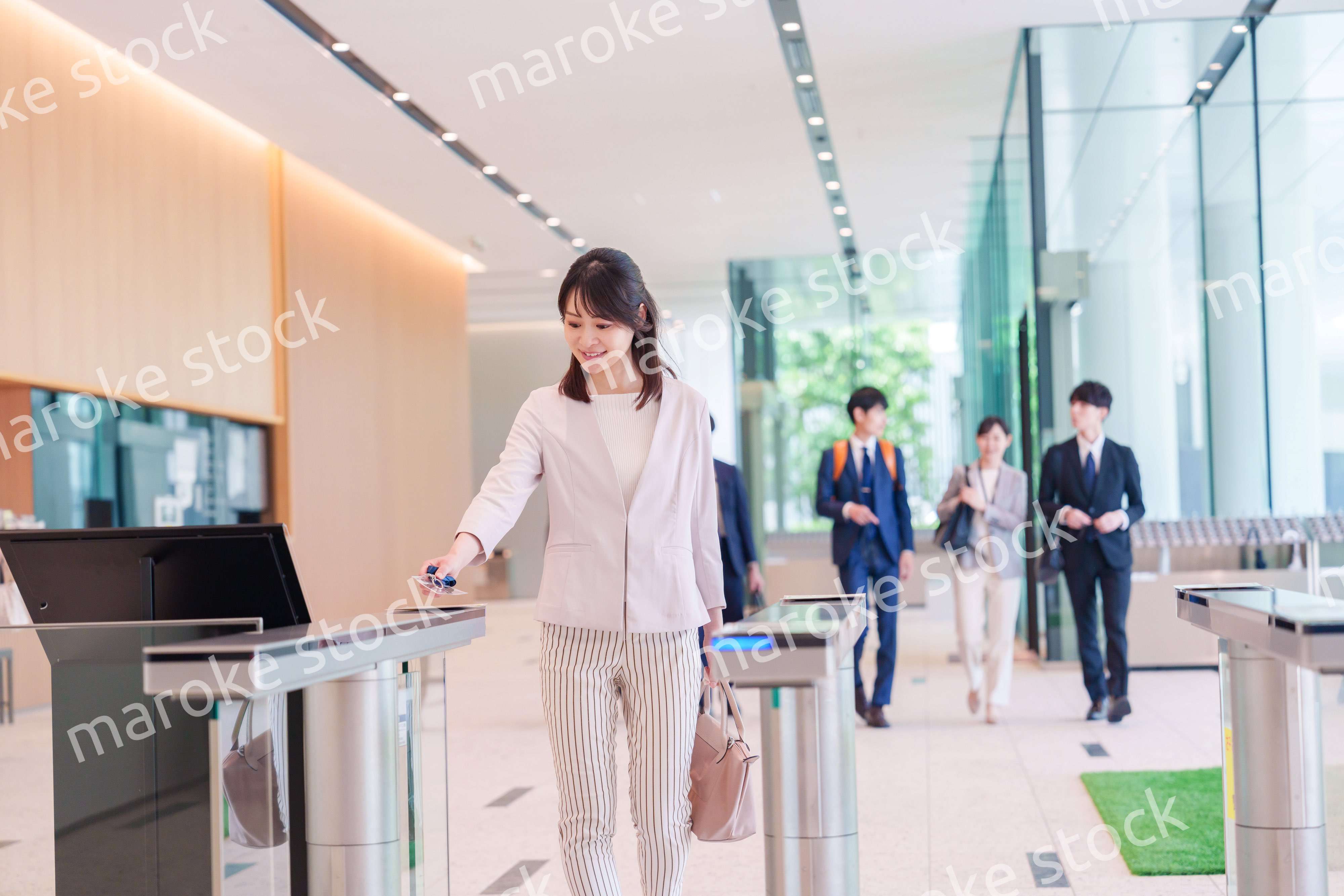 オフィスのセキュリティゲートを通るビジネスウーマン