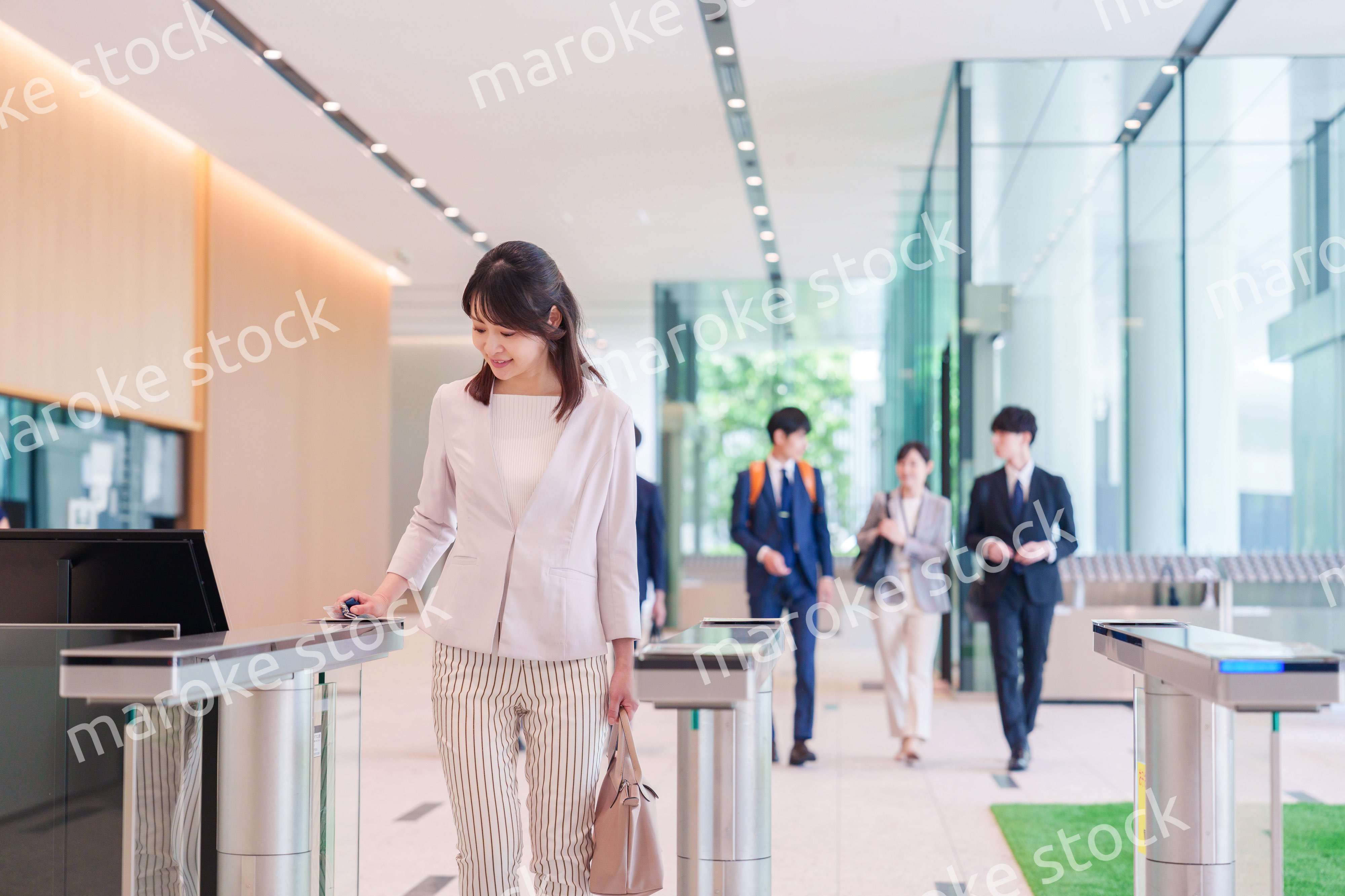 オフィスのセキュリティゲートを通るビジネスウーマン