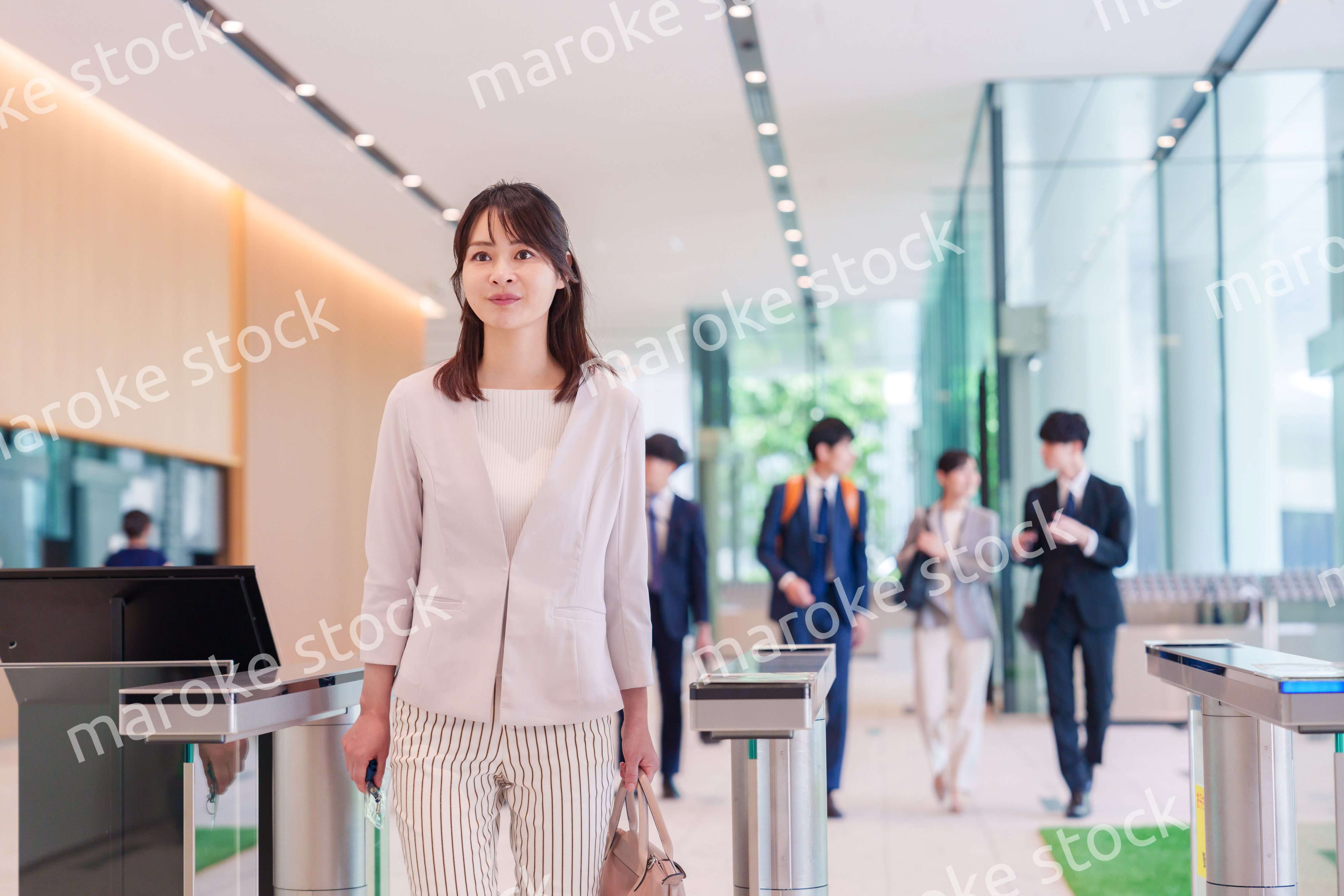 オフィスのセキュリティゲートを通るビジネスウーマン