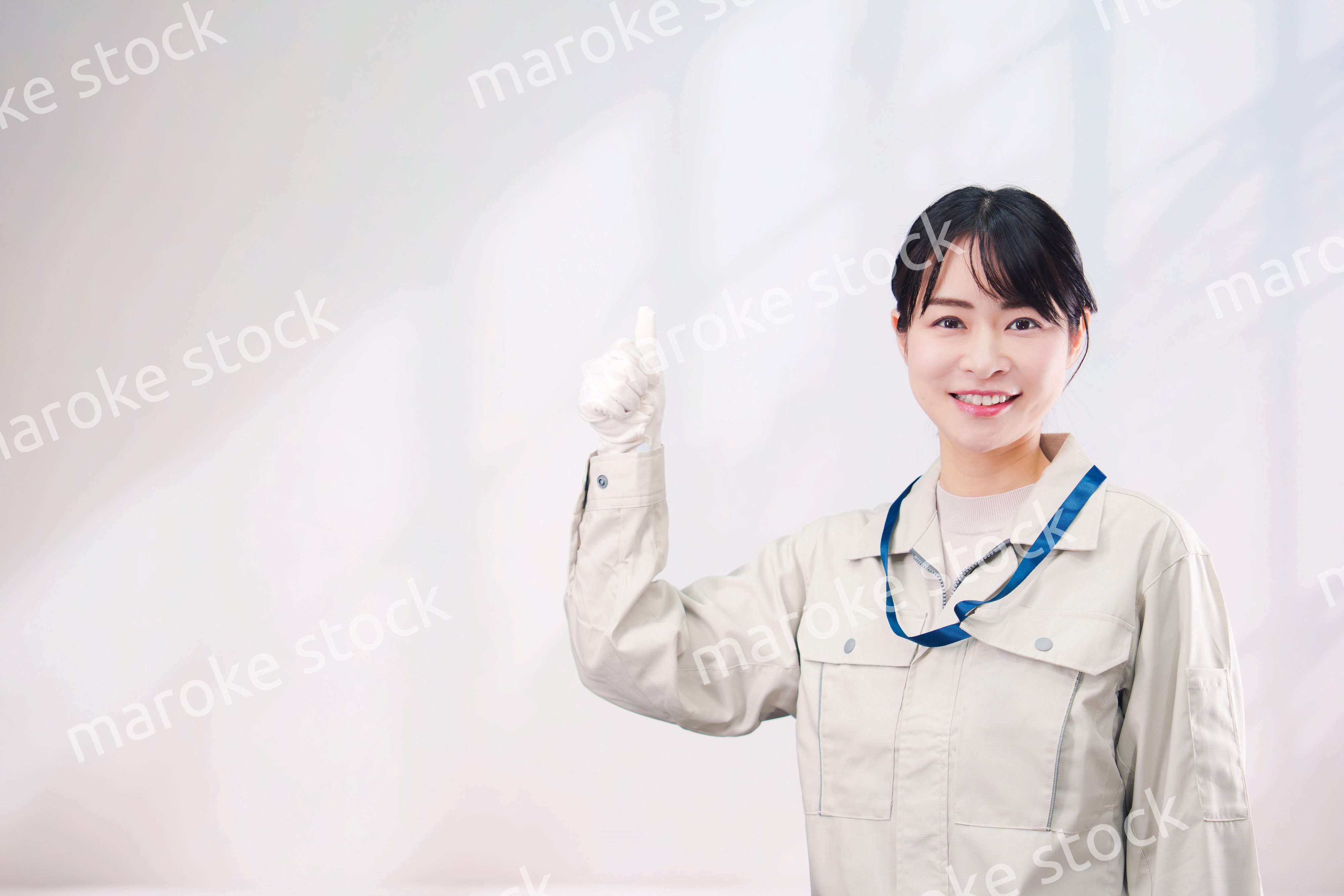 作業服を着て笑顔の若い女性（シンプル背景）