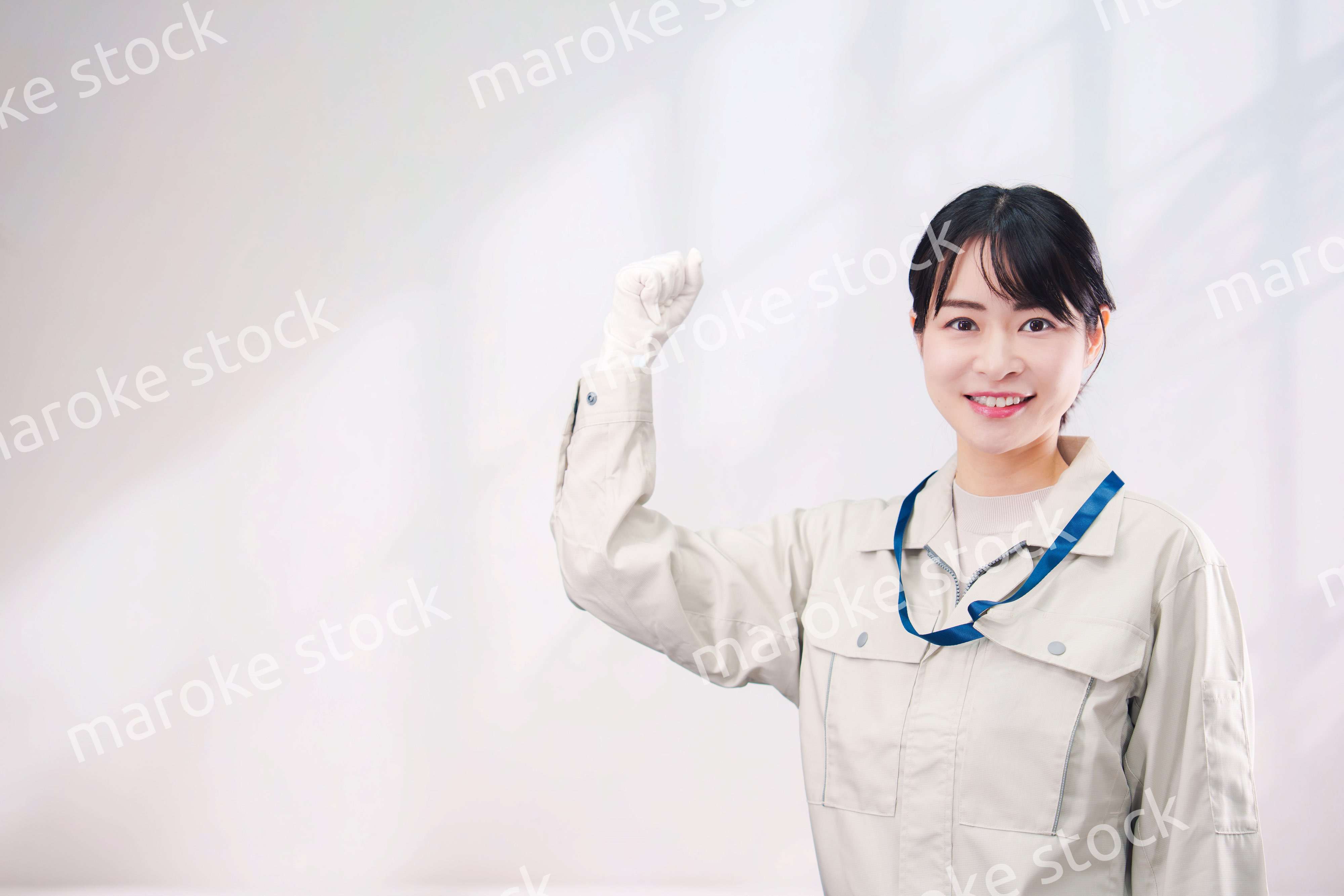 作業服を着て笑顔の若い女性（シンプル背景）