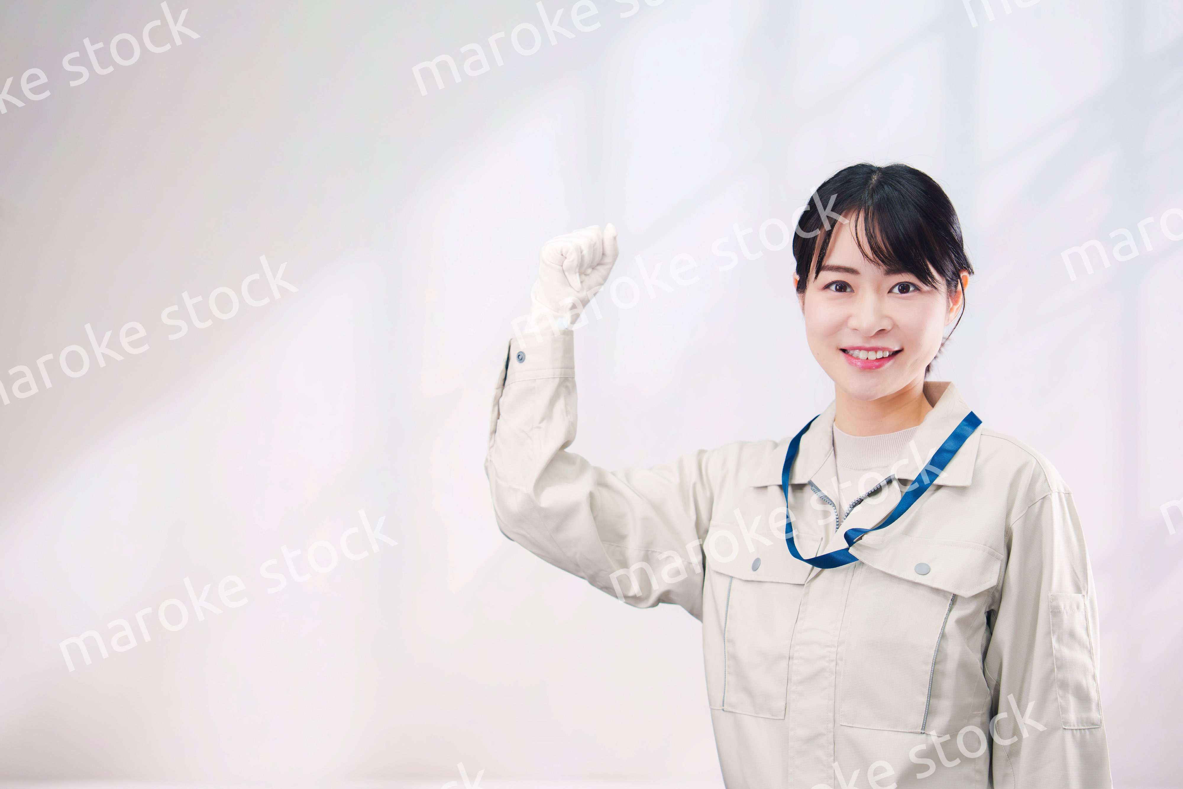 作業服を着て笑顔の若い女性（シンプル背景）