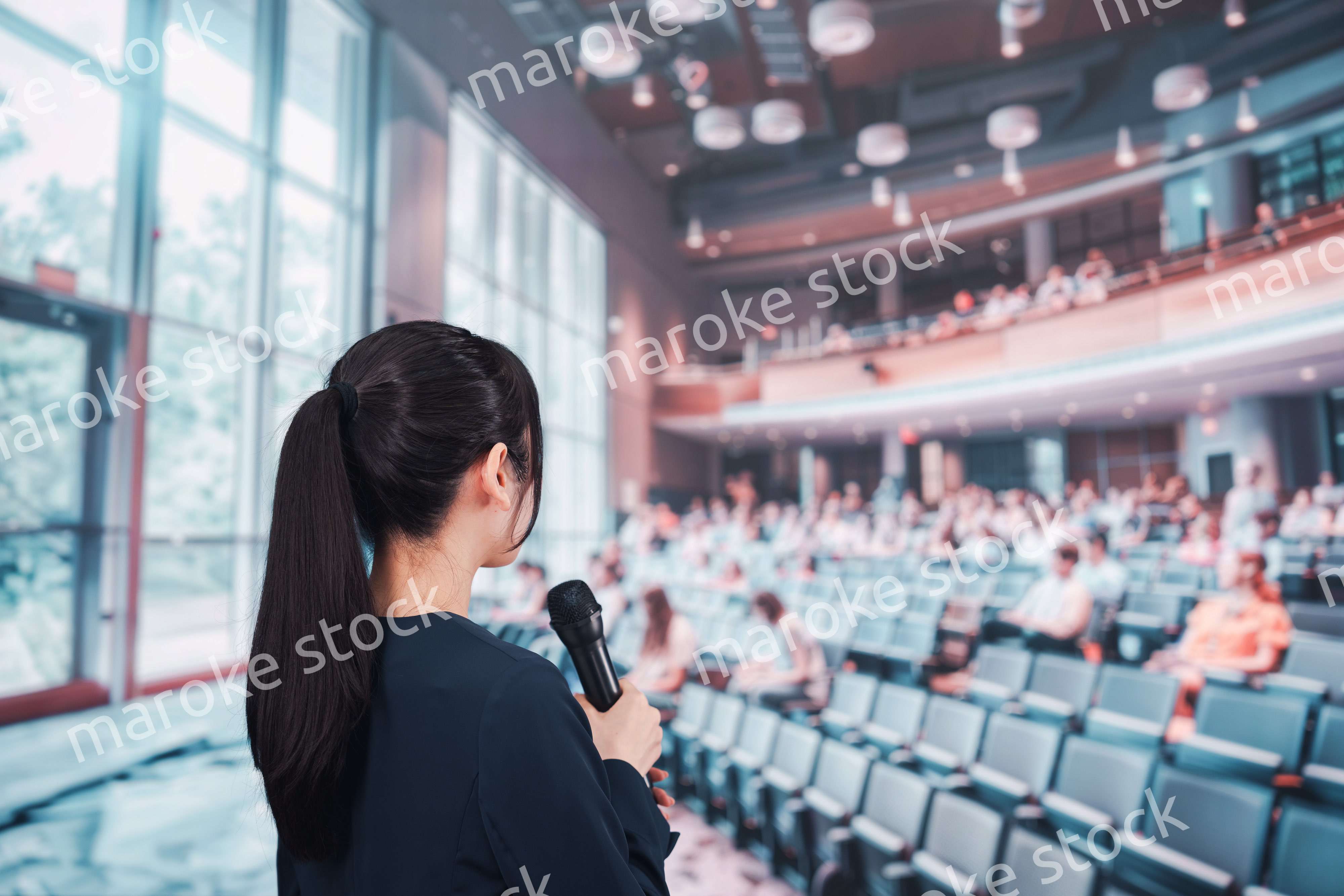 ホールで司会をする若い女性