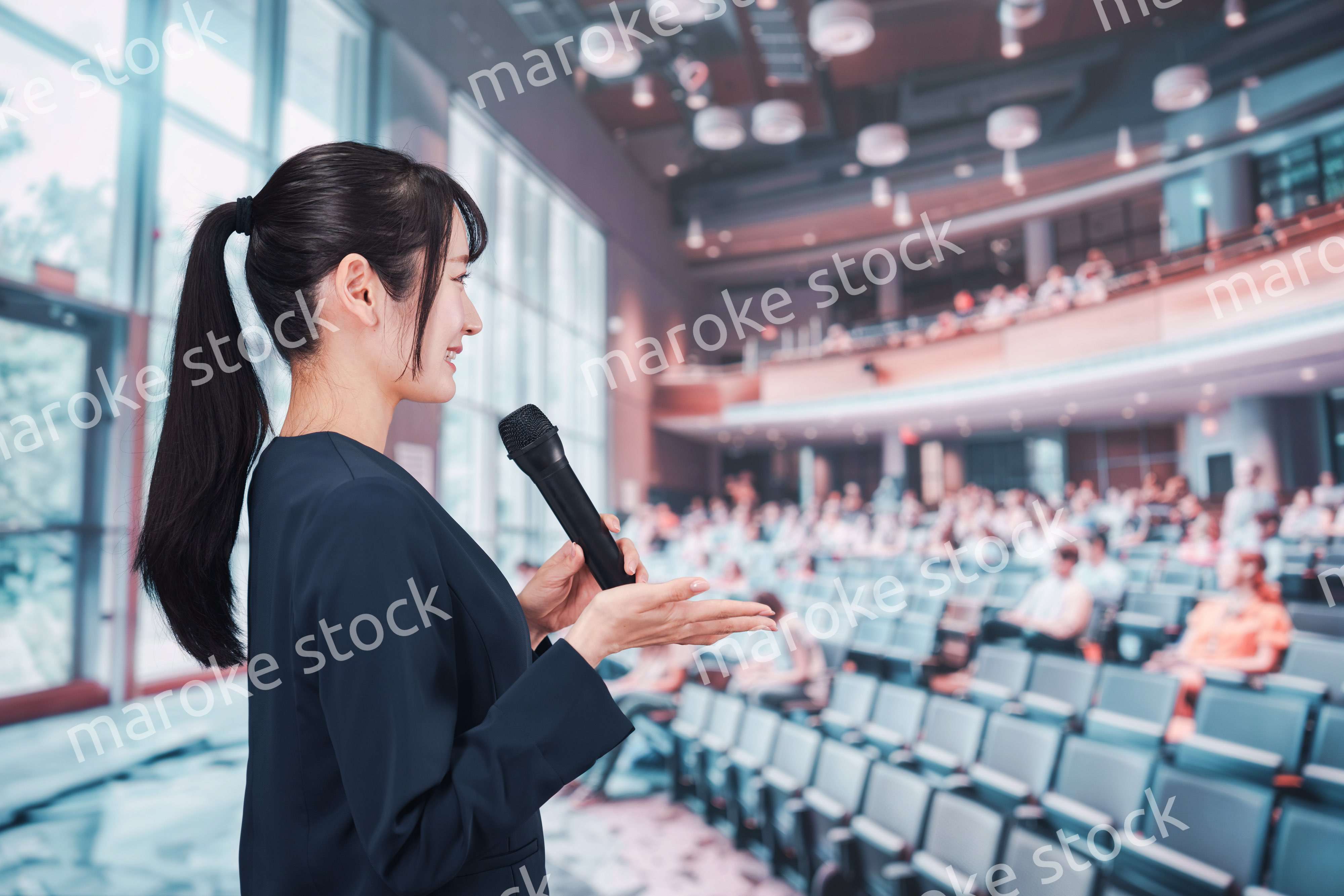 ホールで司会をする若い女性