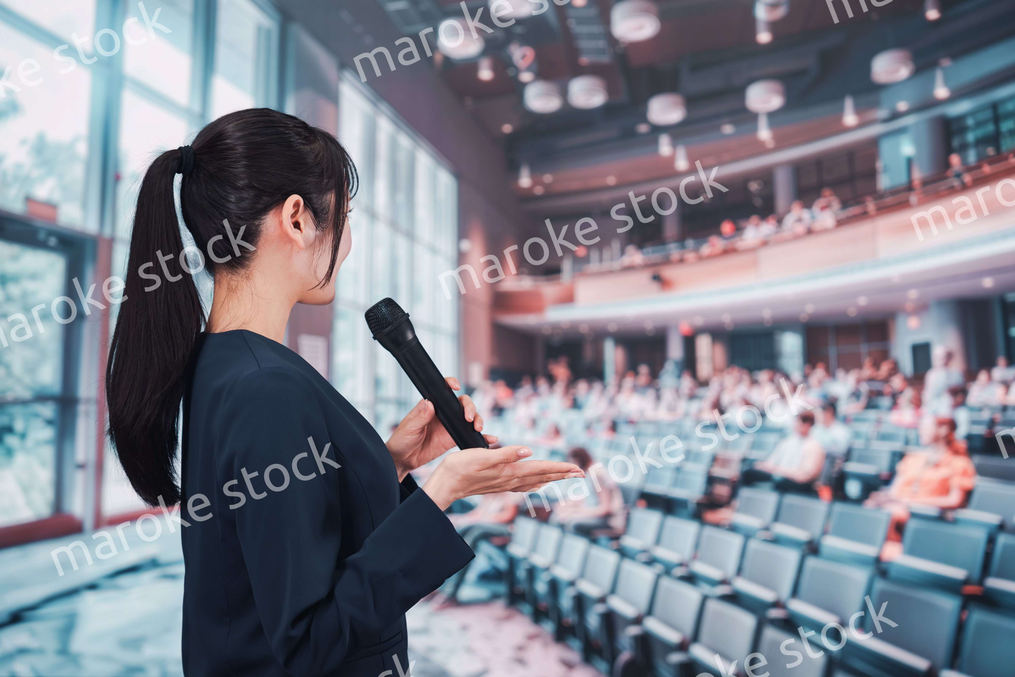 ホールで司会をする若い女性