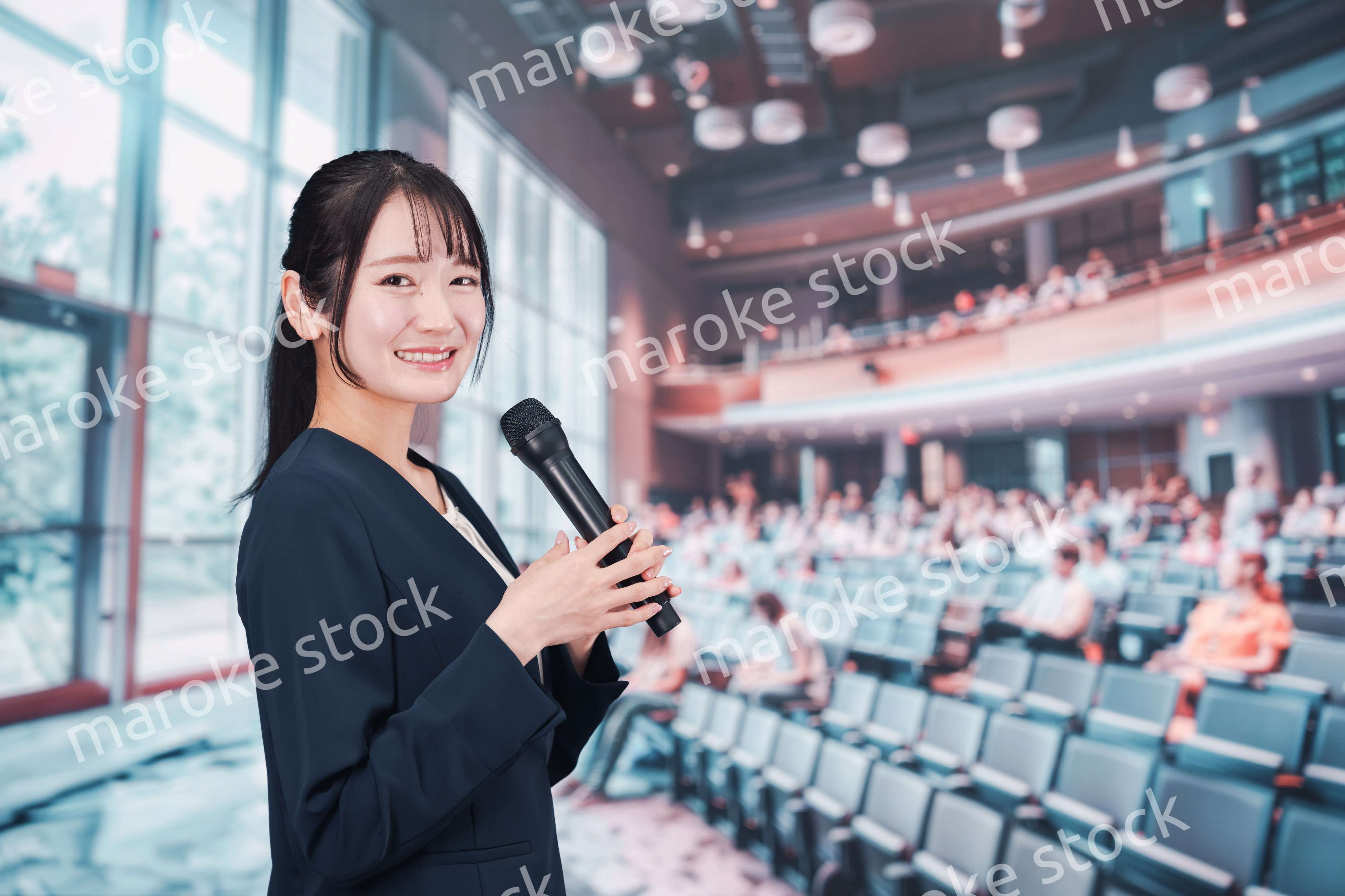 ホールで司会をする若い女性