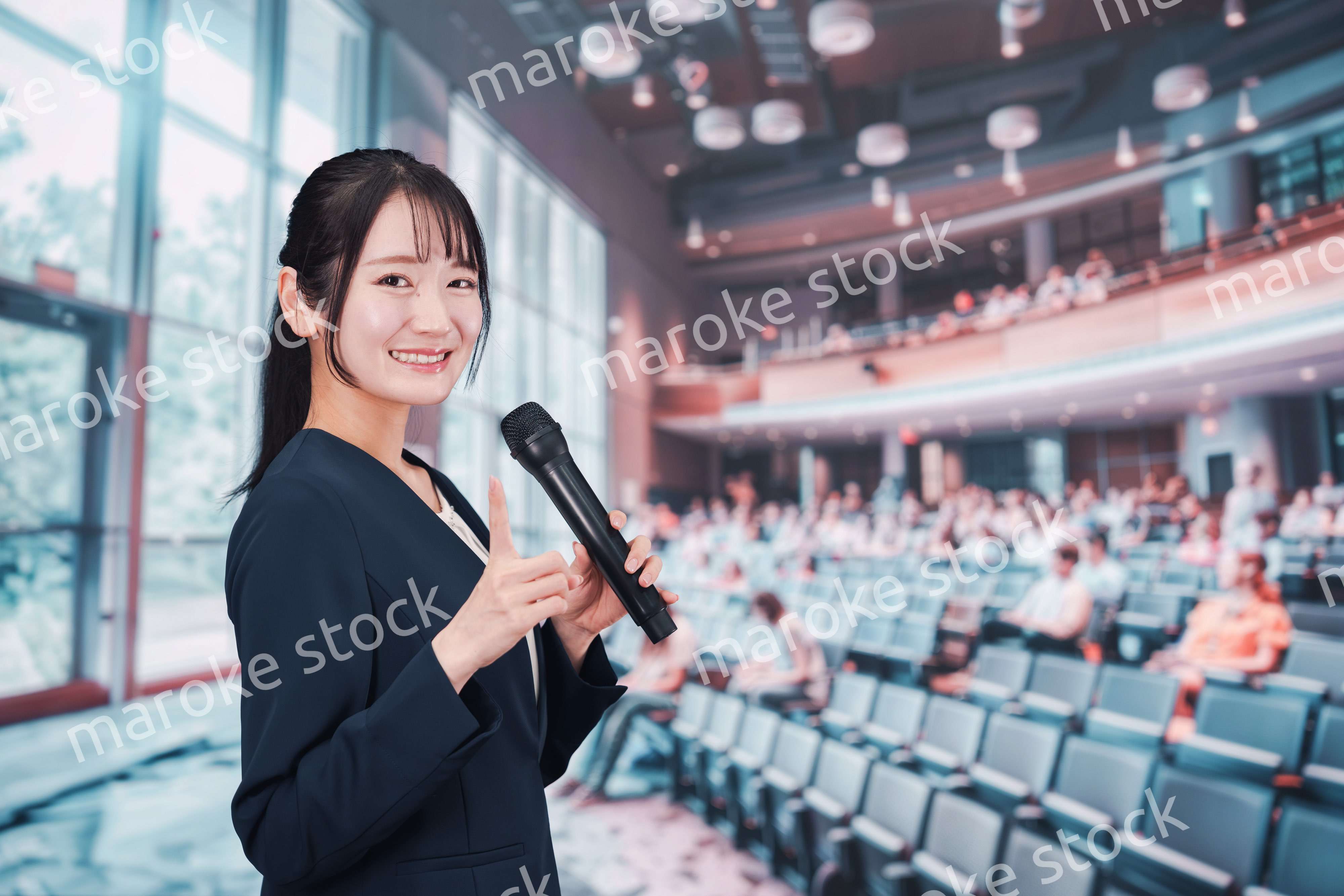 ホールで司会をする若い女性