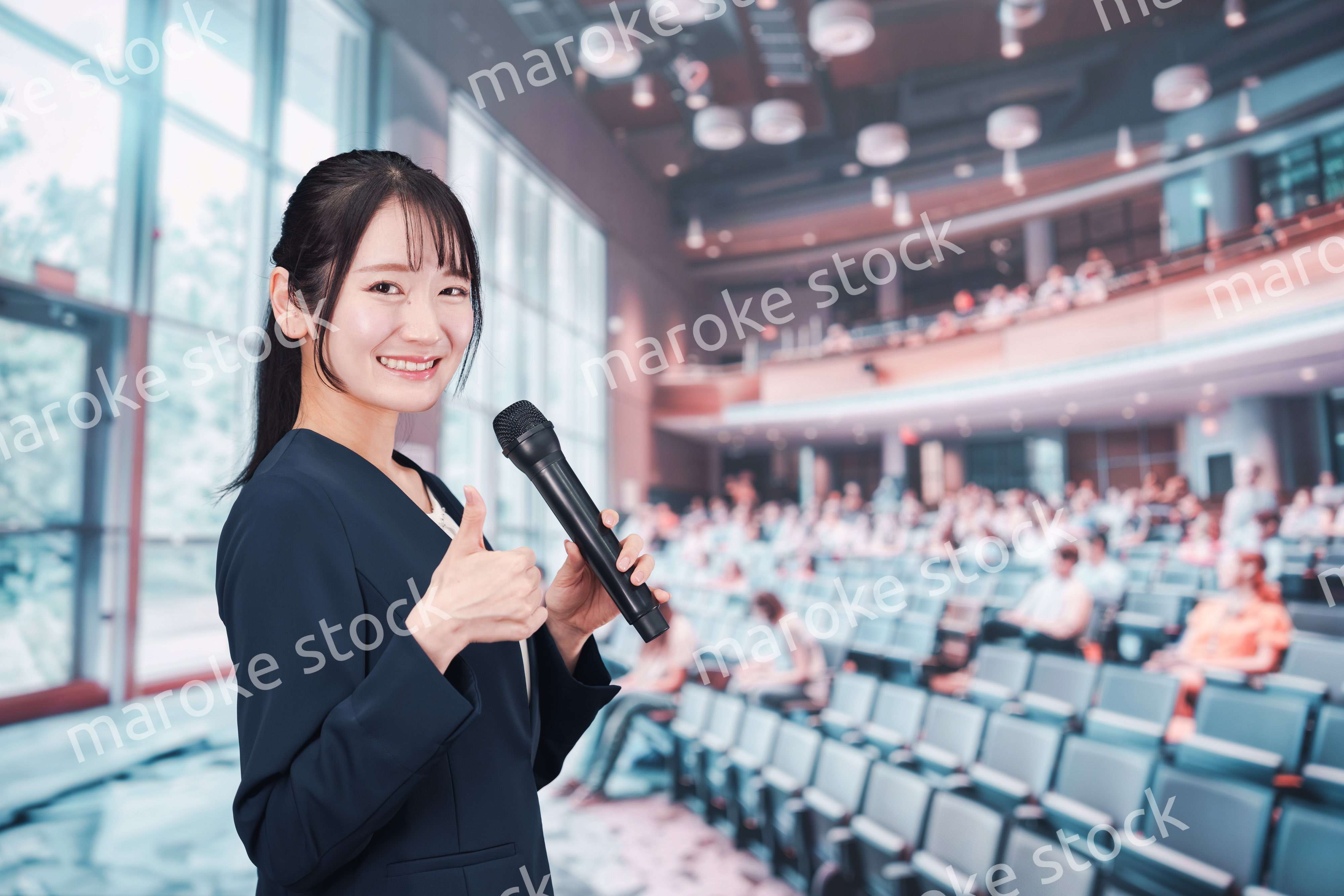 ホールで司会をする若い女性