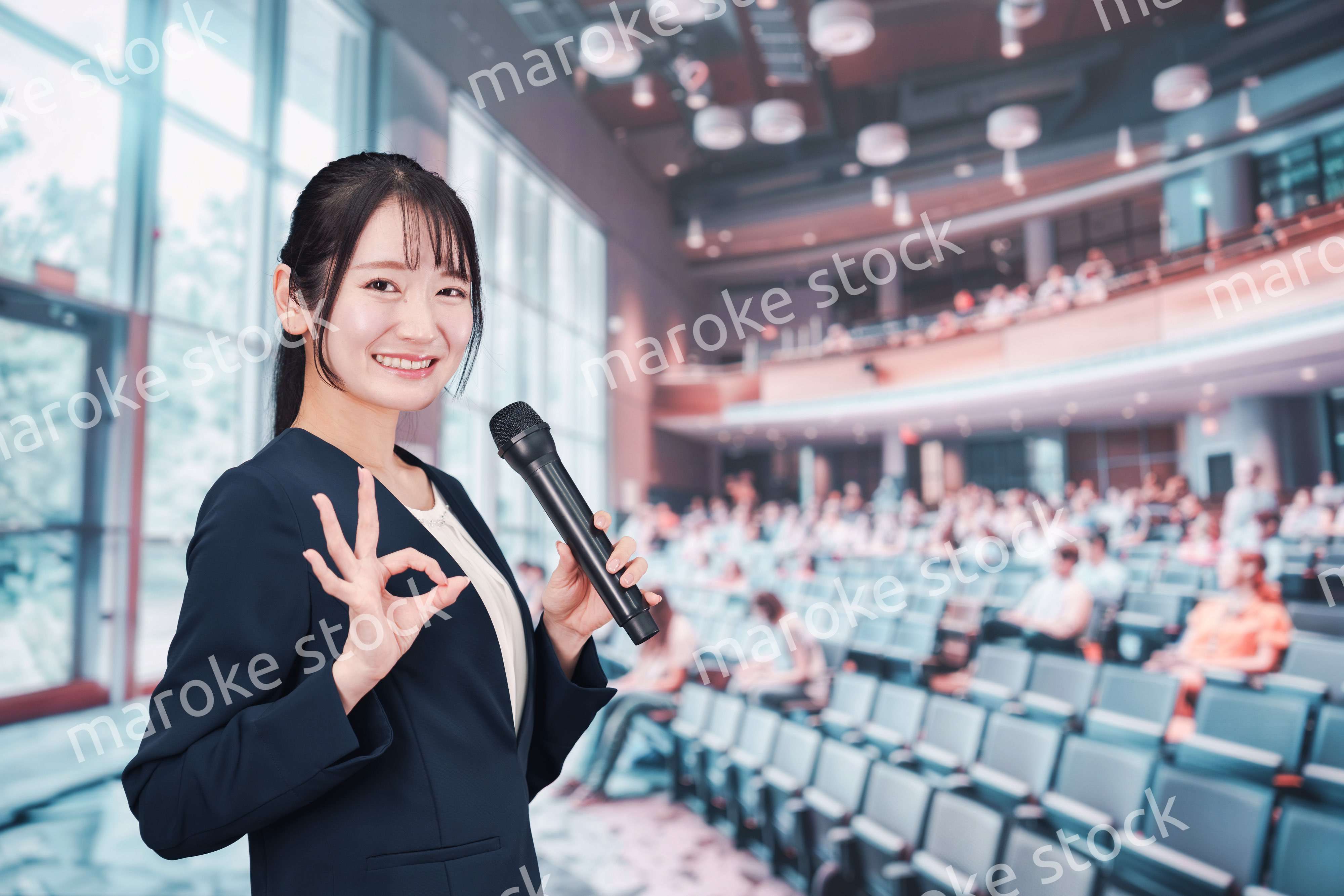 ホールで司会をする若い女性