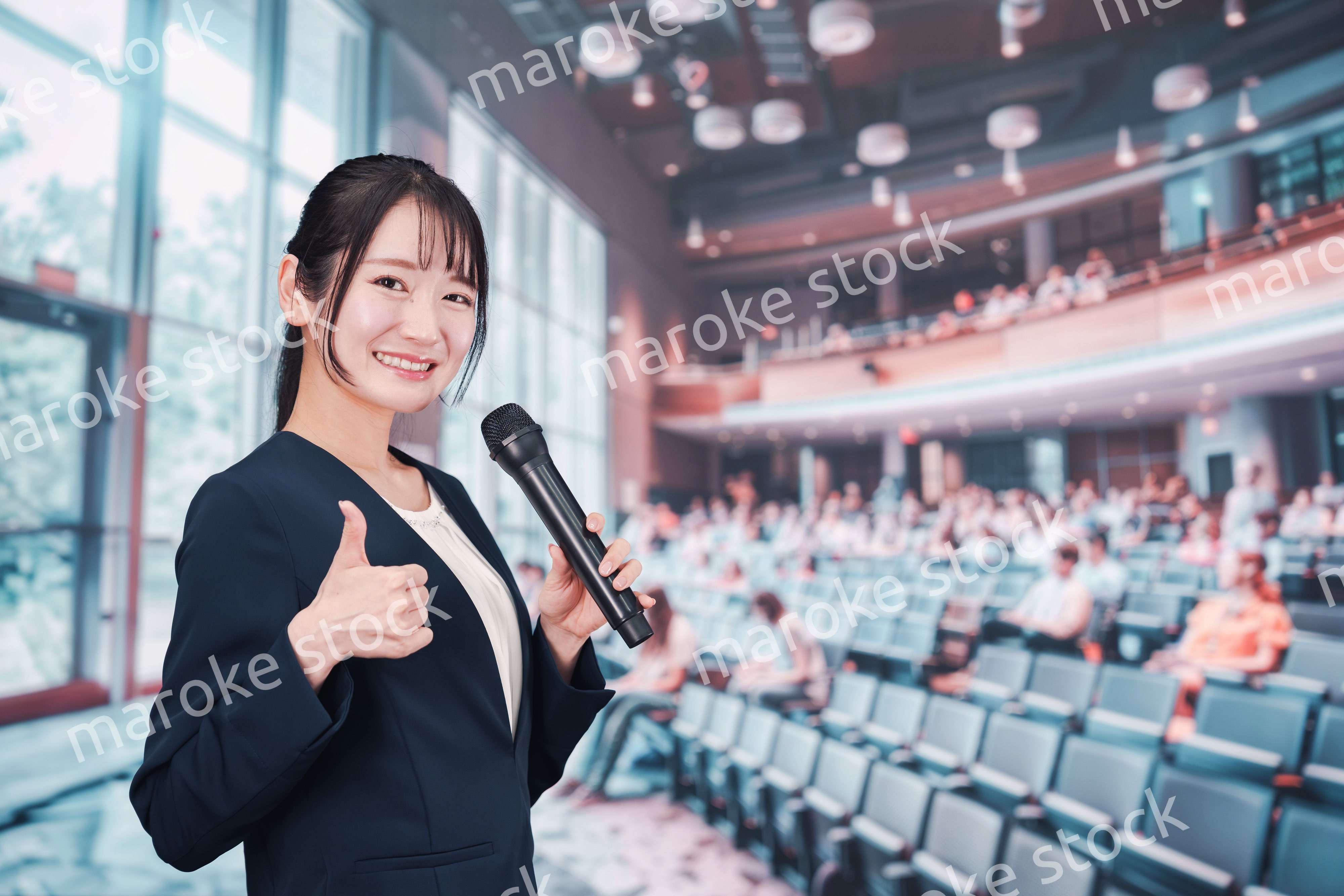 ホールで司会をする若い女性