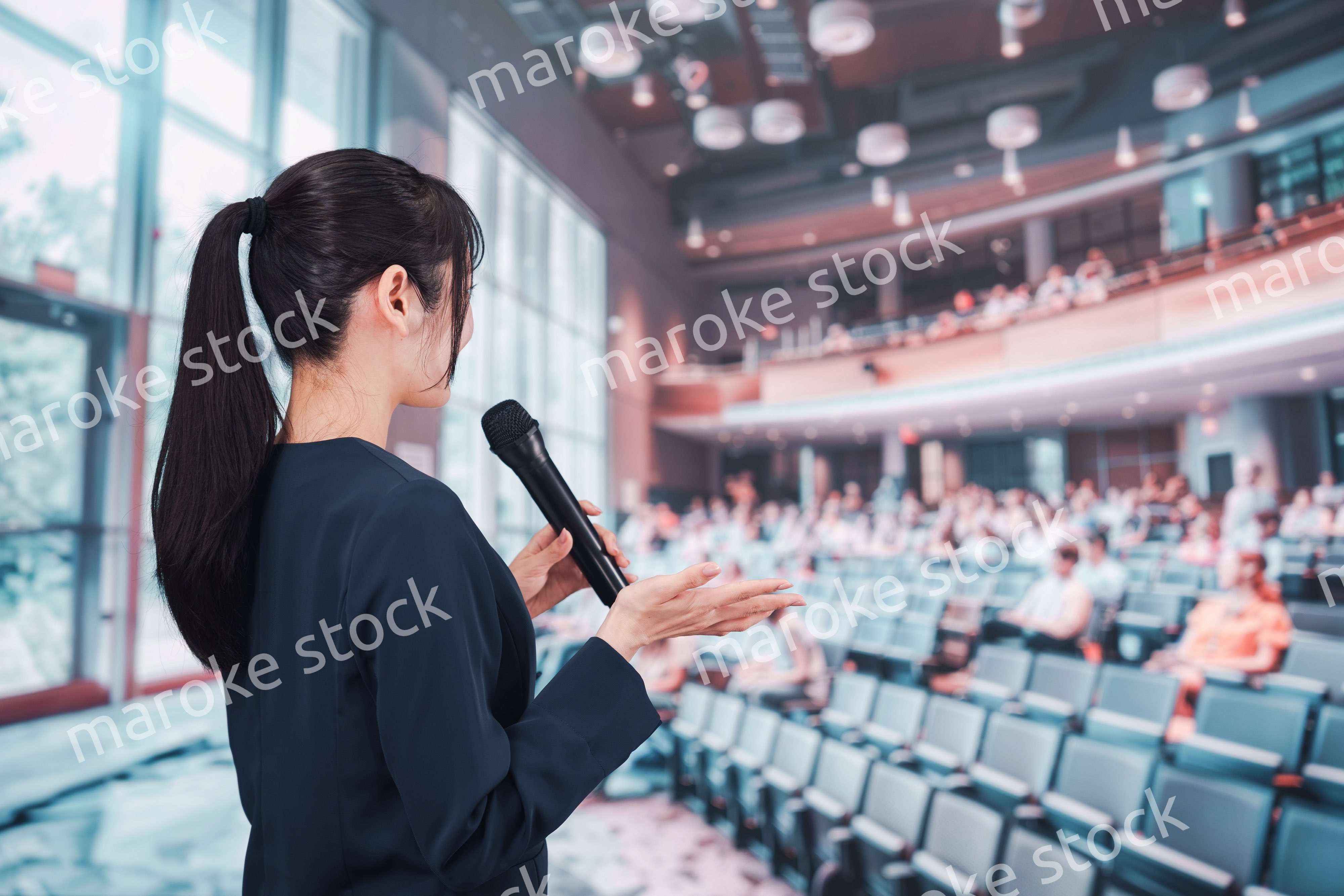 ホールで司会をする若い女性