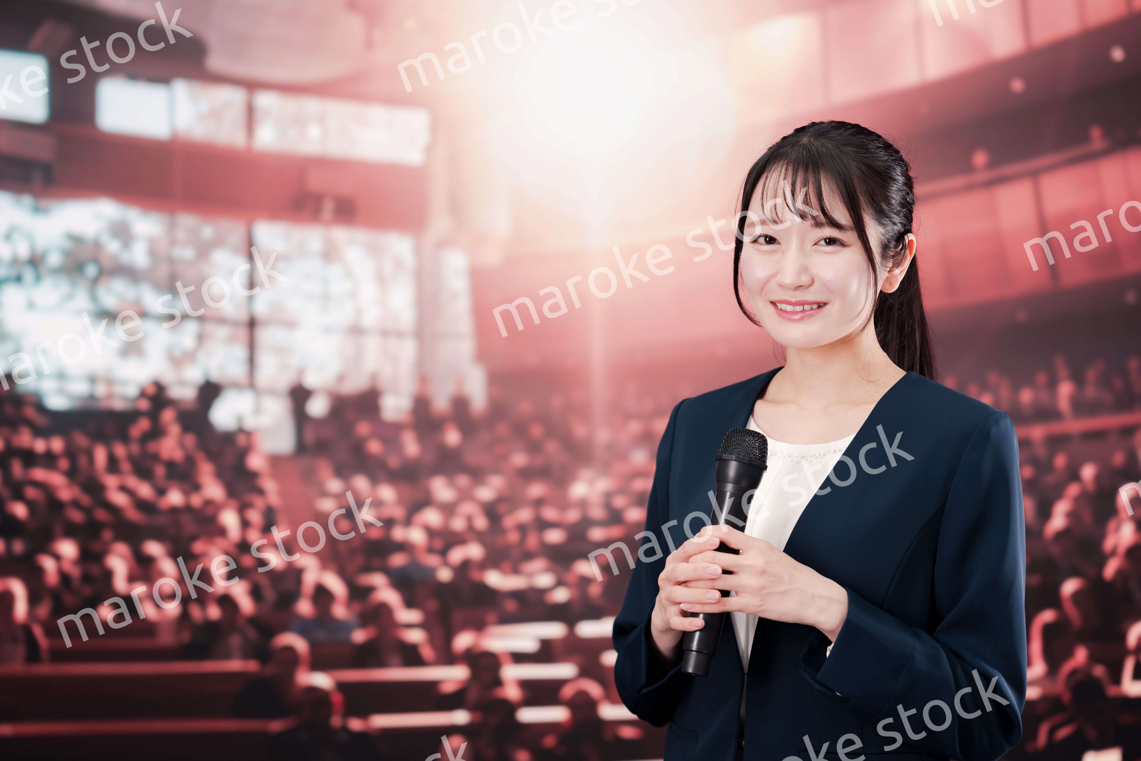 大勢の聴衆の前で話す女性