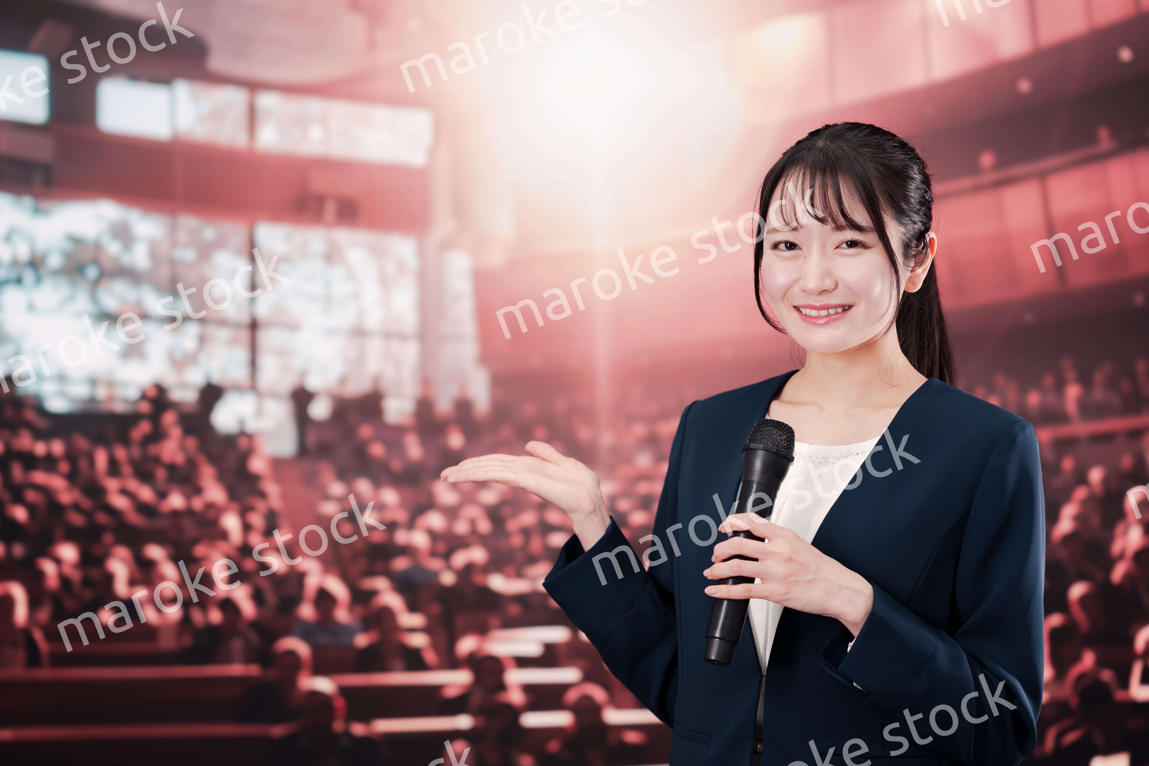 大勢の聴衆の前で話す女性
