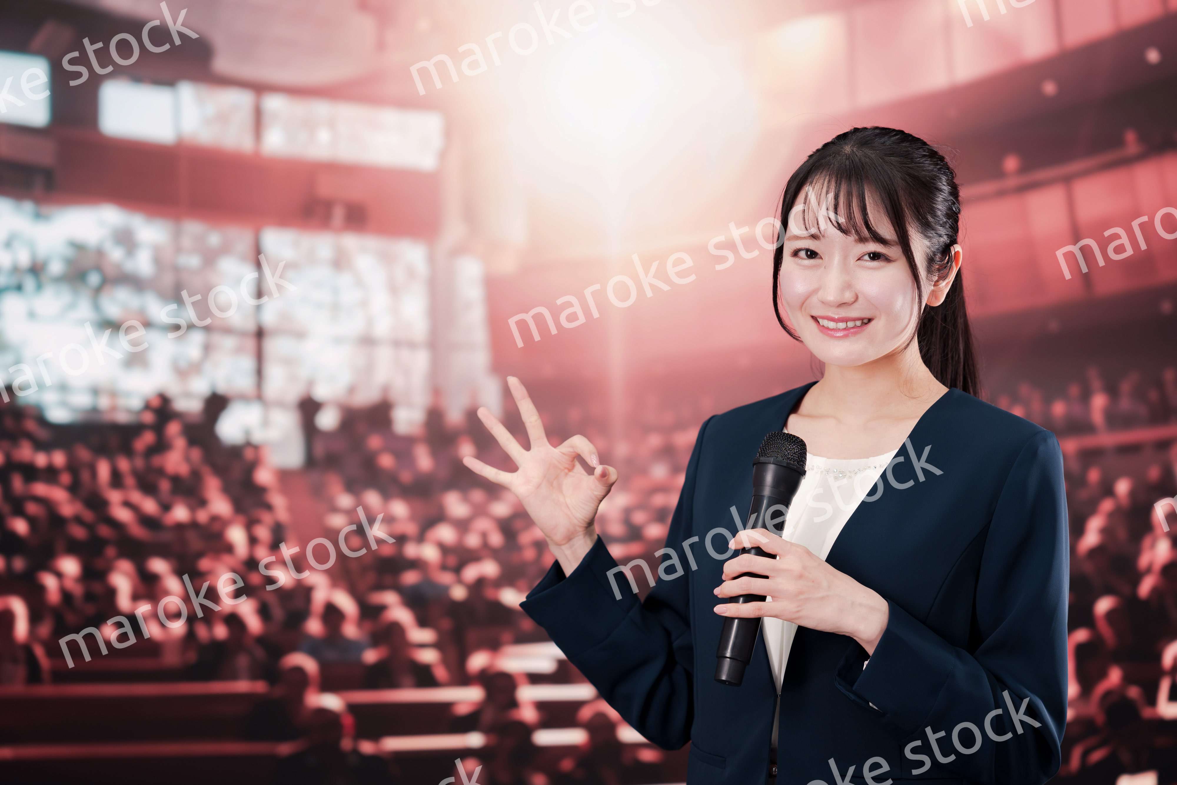 大勢の聴衆の前で話す女性