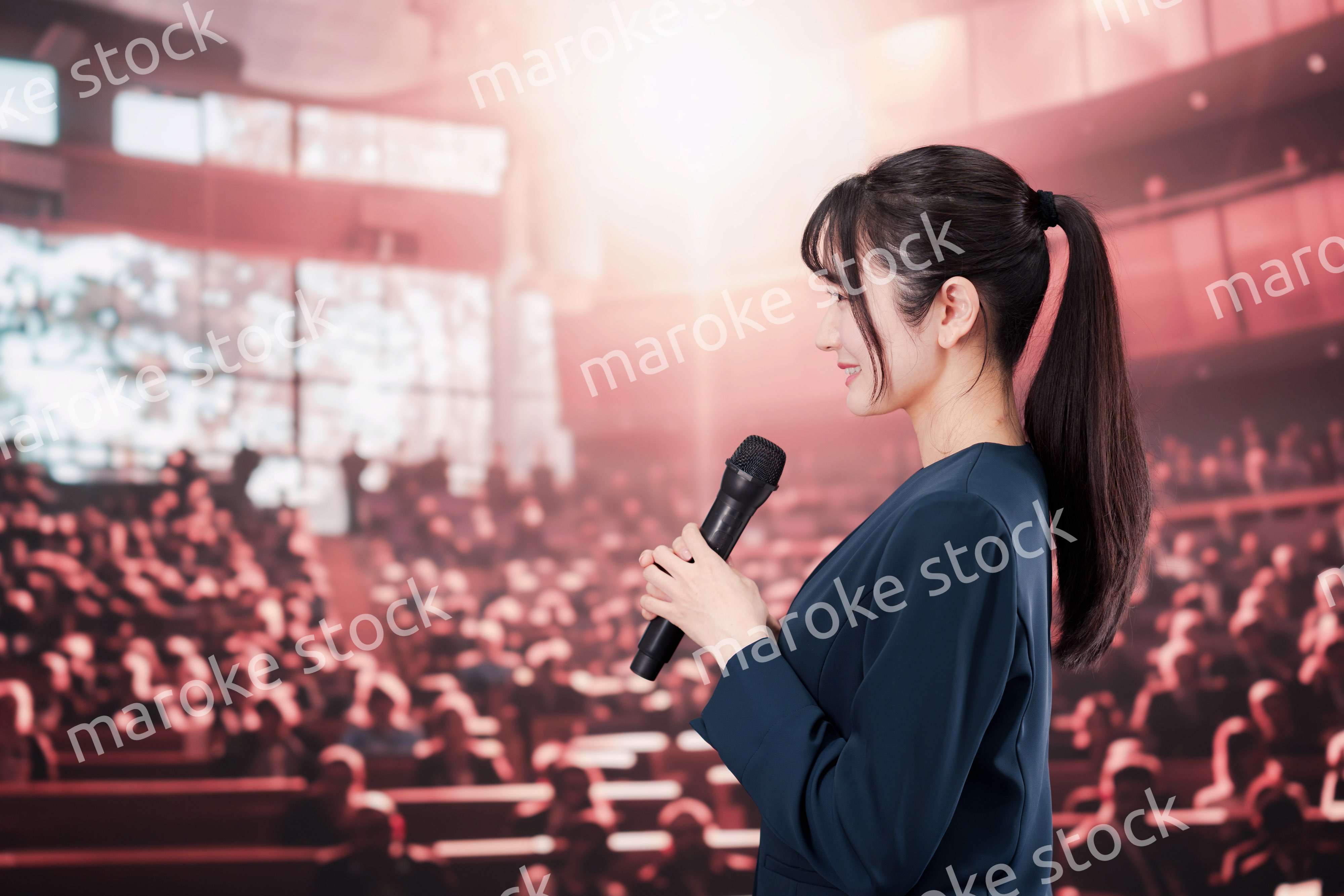 大勢の聴衆の前で話す女性