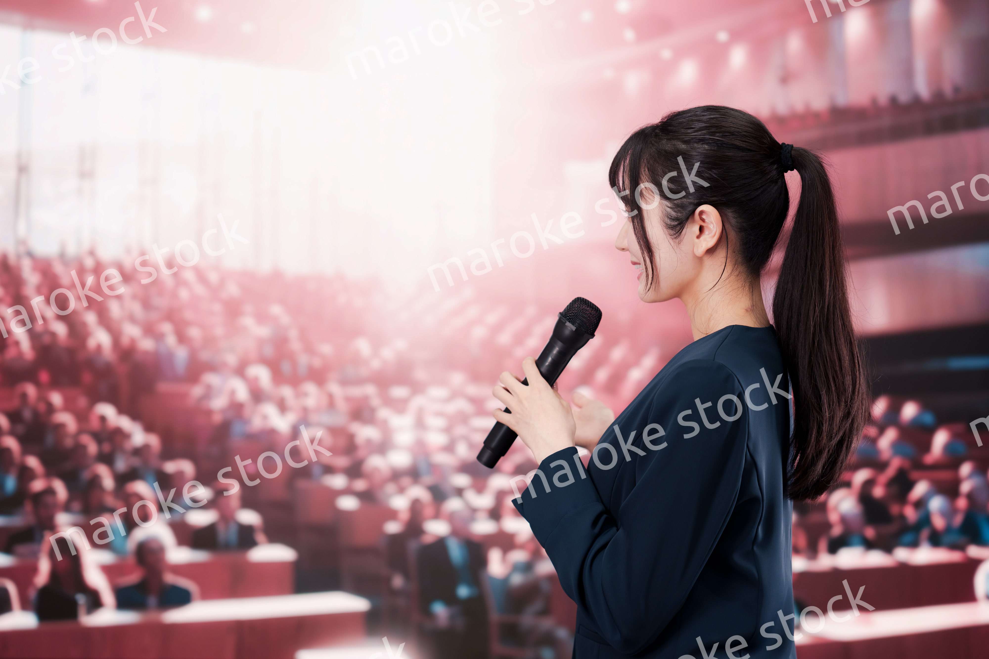 大勢の聴衆の前で話す女性