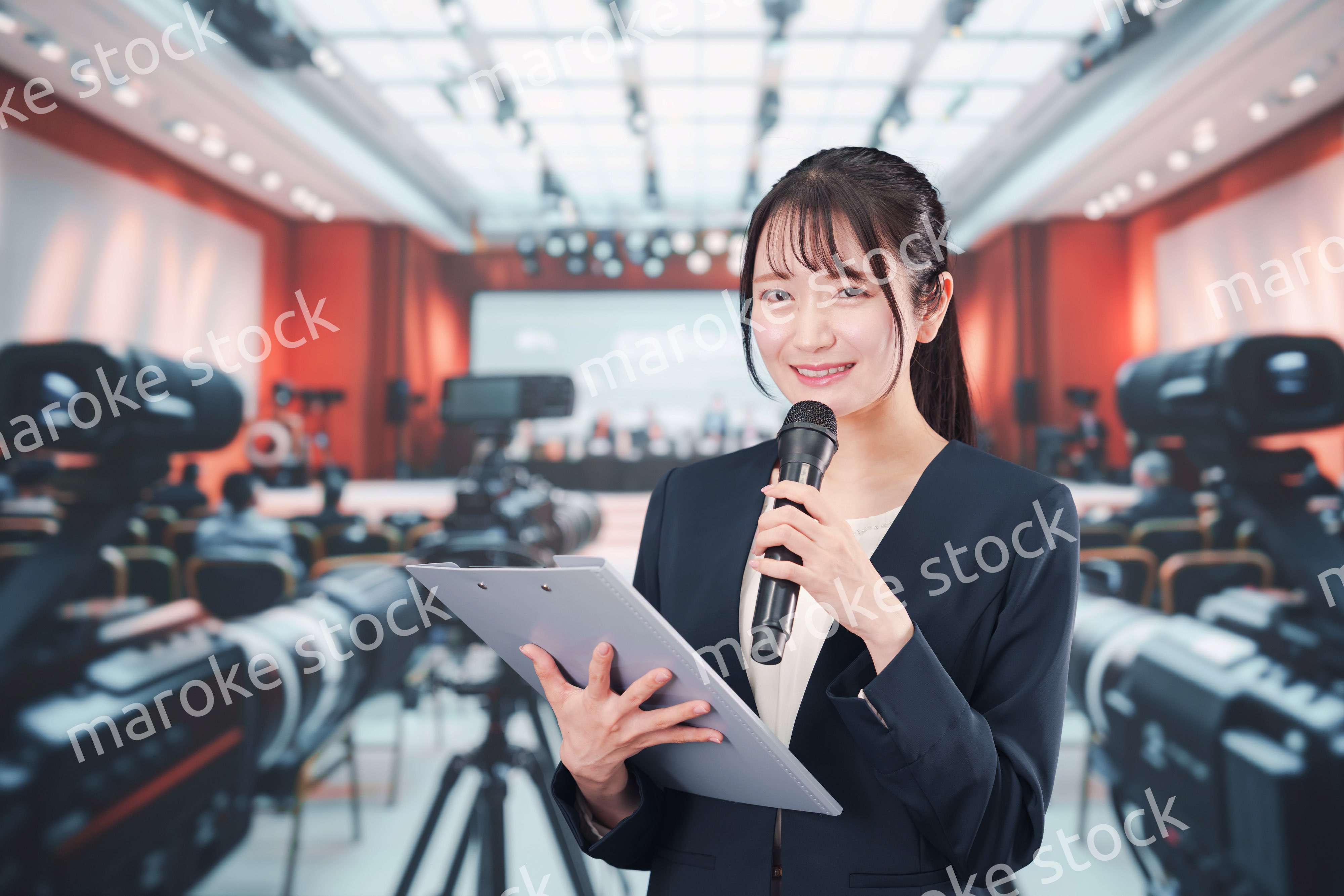 記者会見場からレポートをする女性のアナウンサー