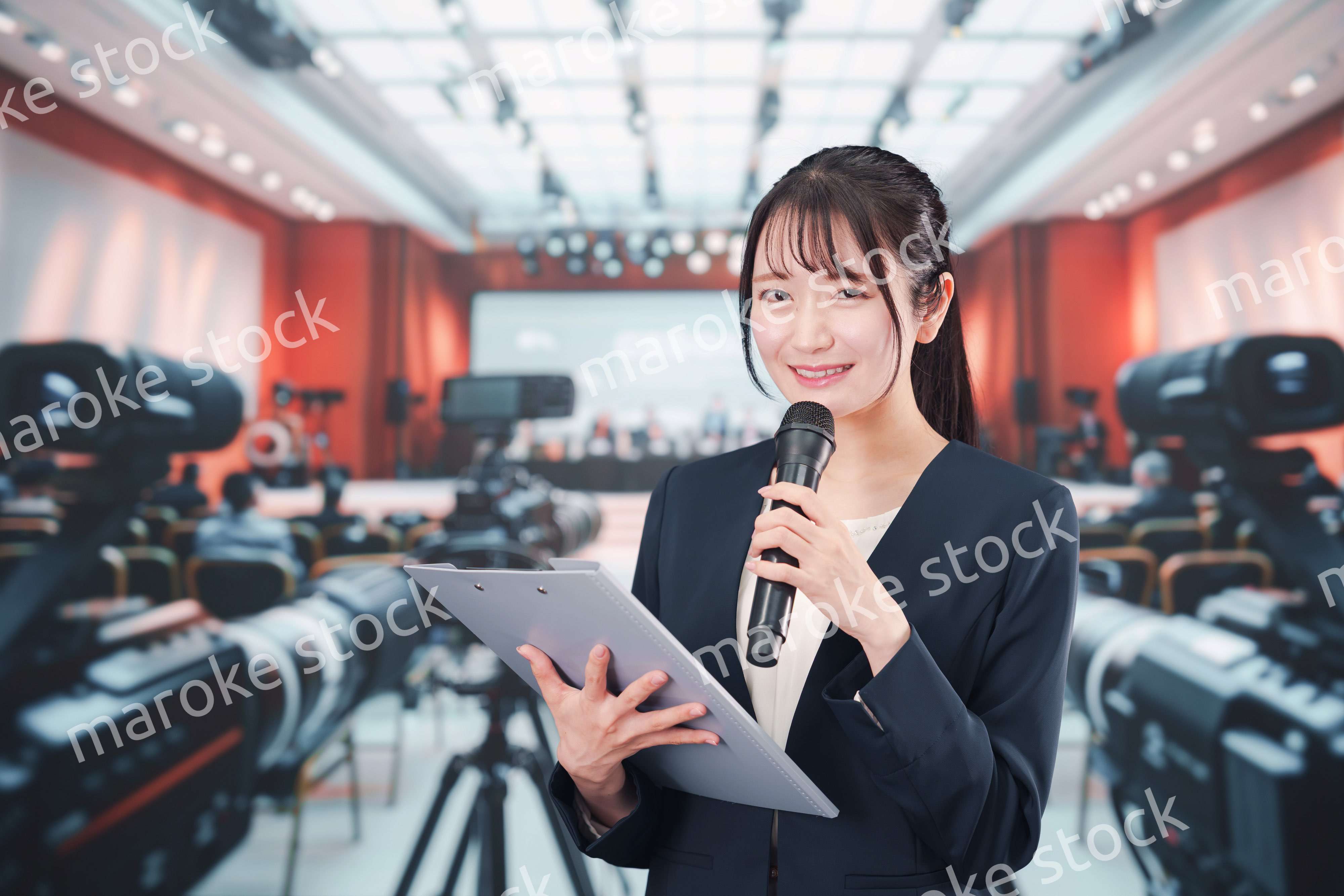 記者会見場からレポートをする女性のアナウンサー