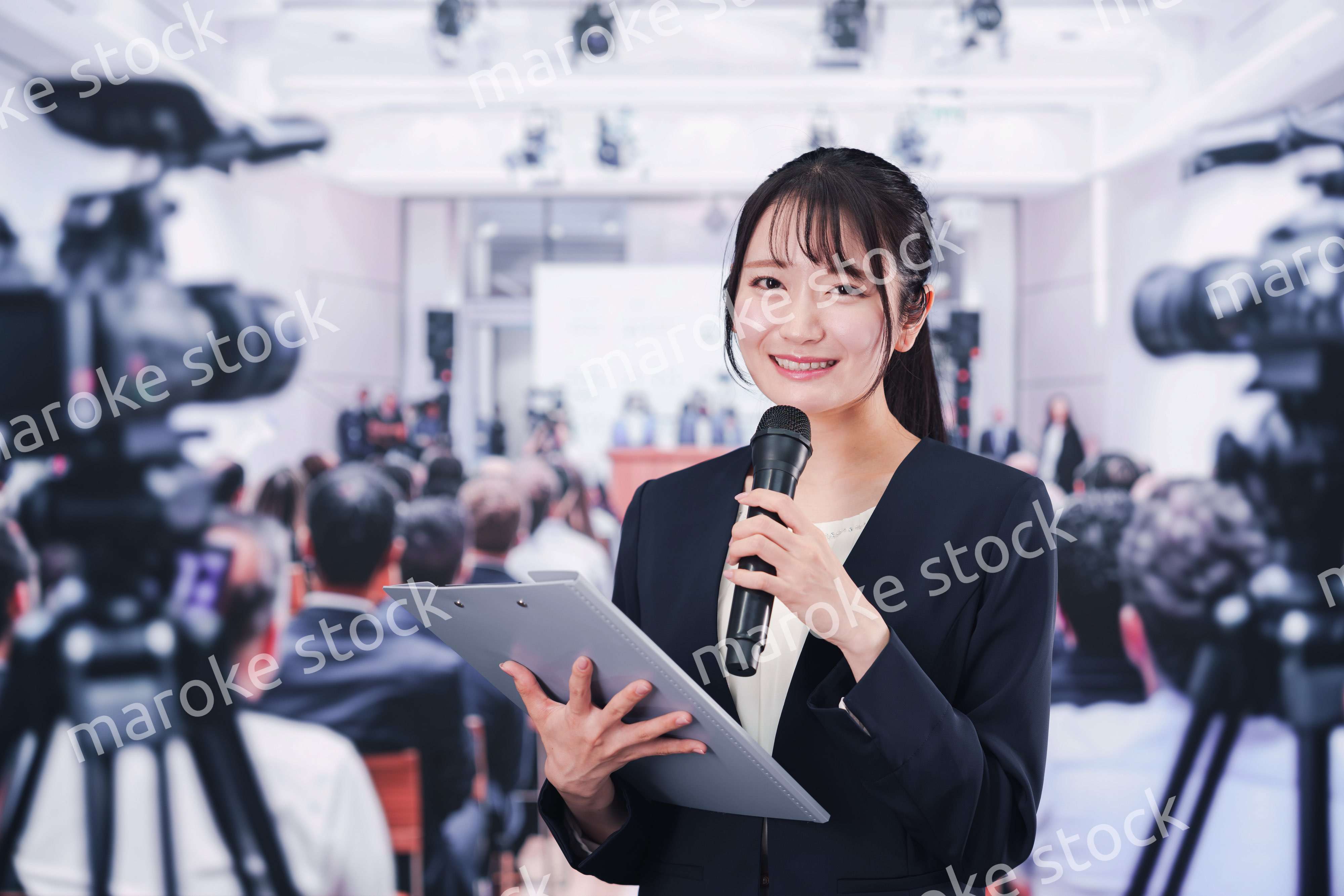 記者会見場からレポートをする女性記者