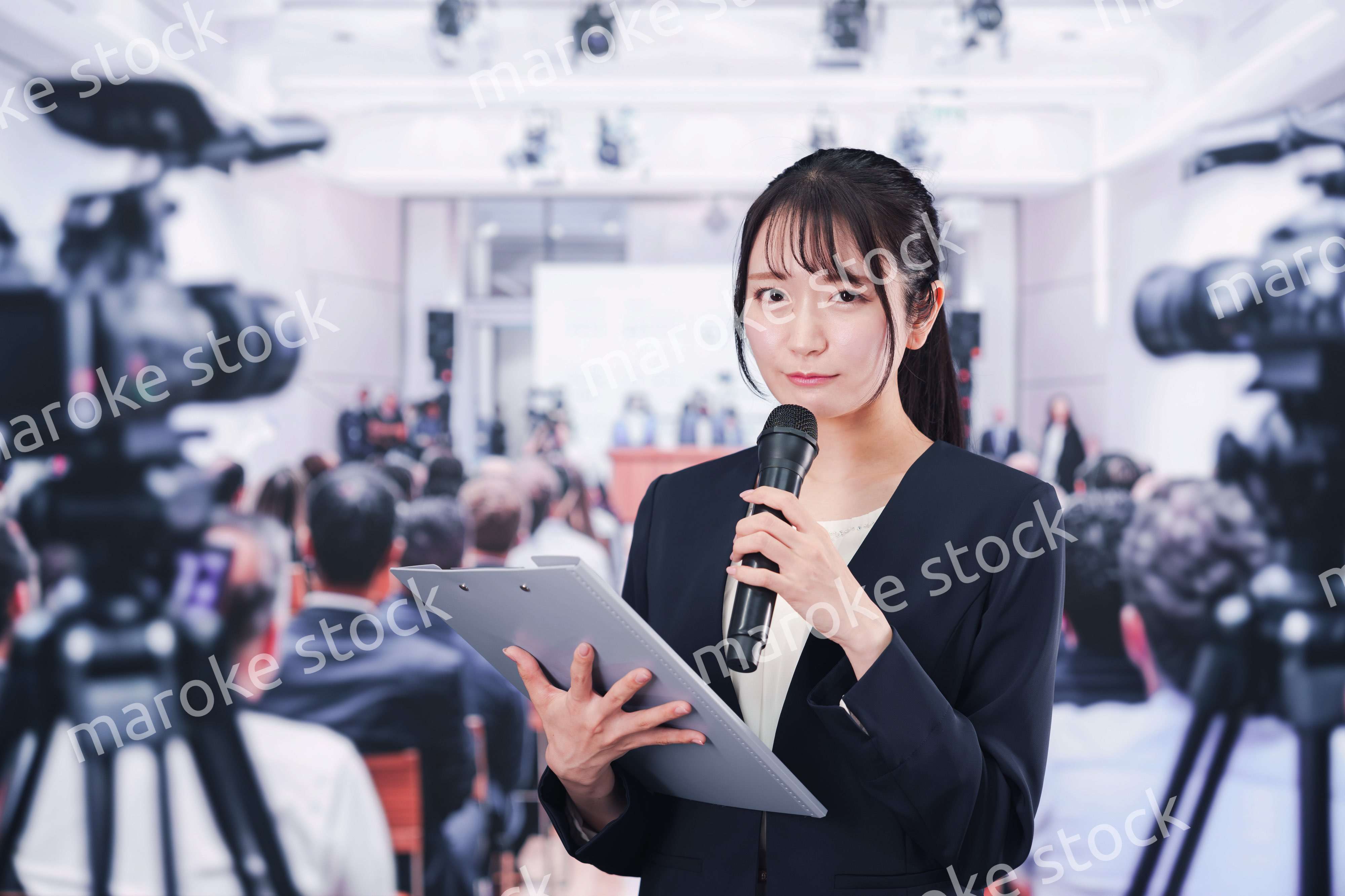 記者会見場からレポートをする女性記者