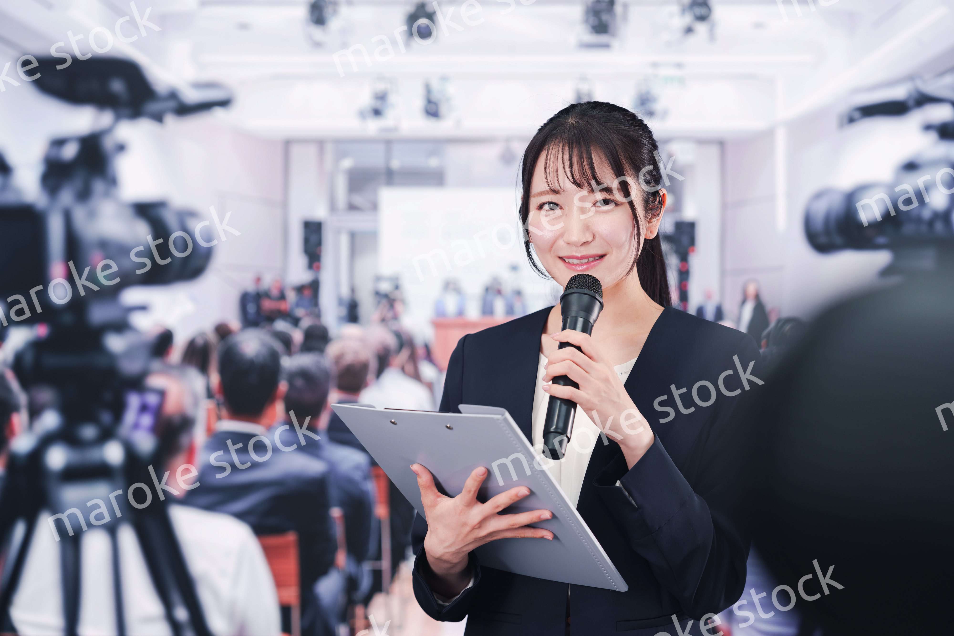 記者会見場からレポートをする女性記者