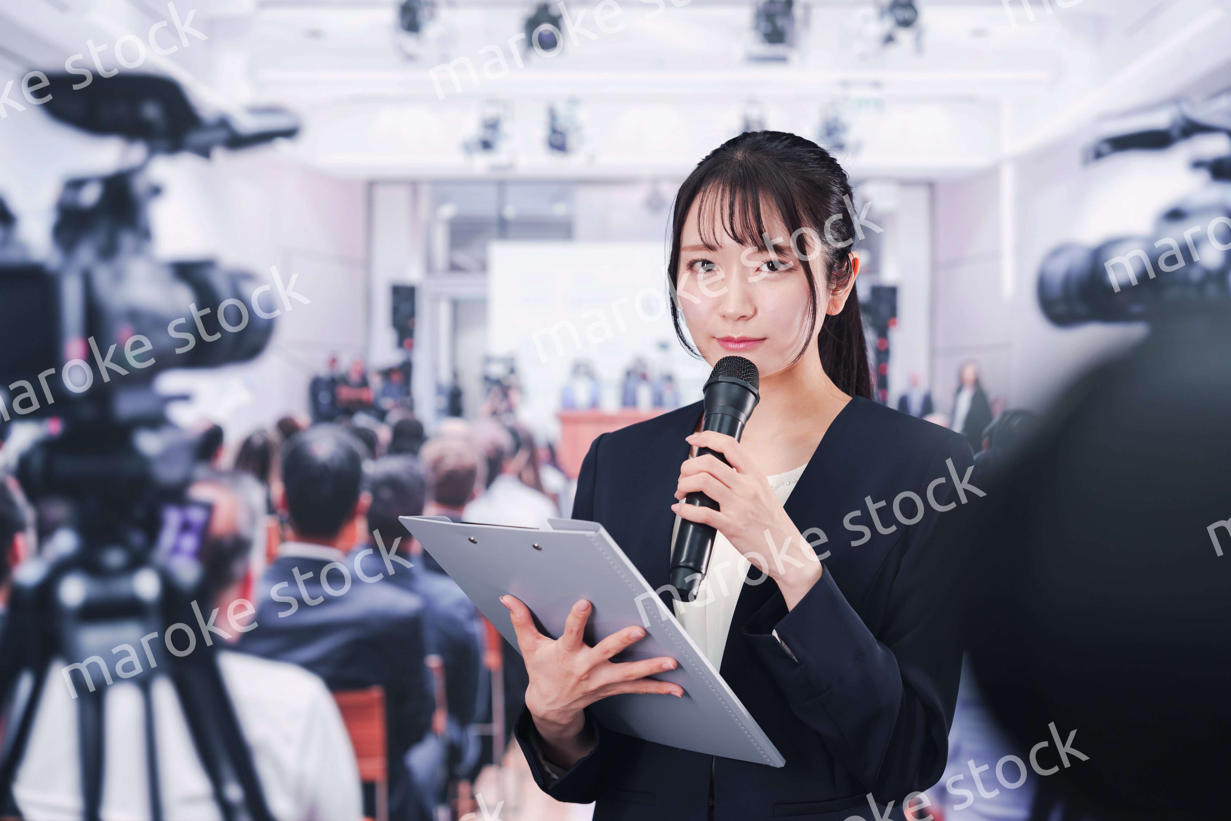 記者会見場からレポートをする女性記者