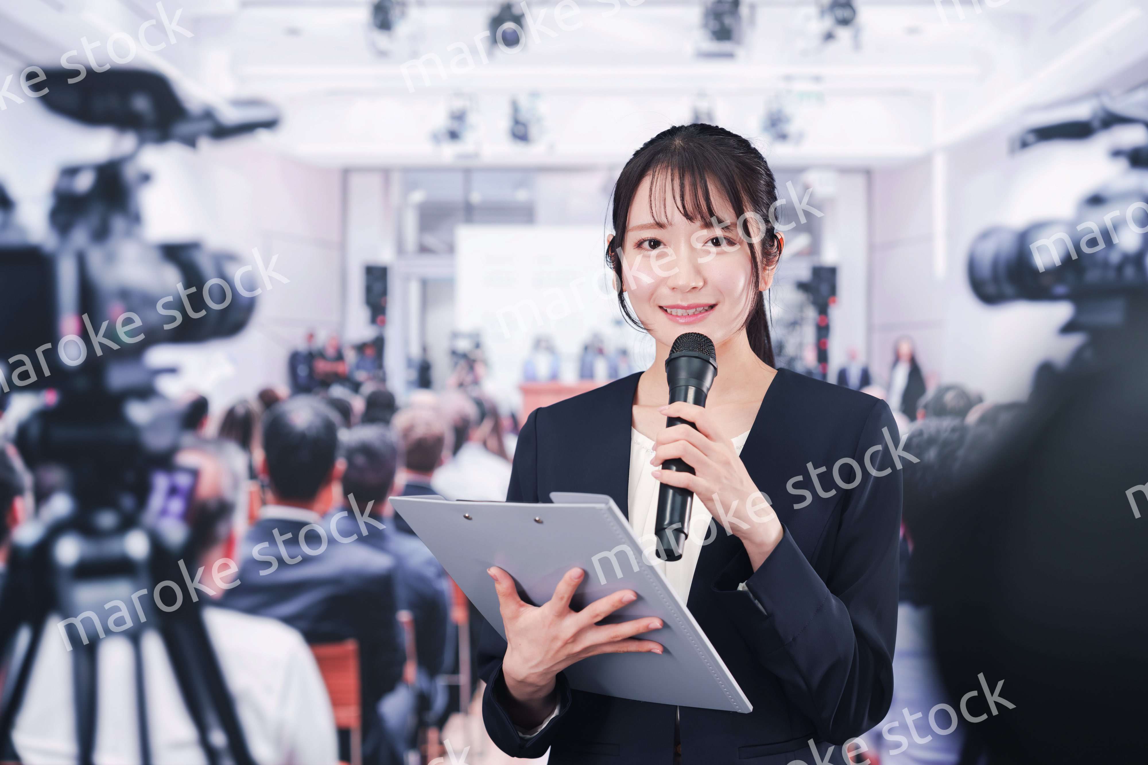 記者会見場からレポートをする女性記者