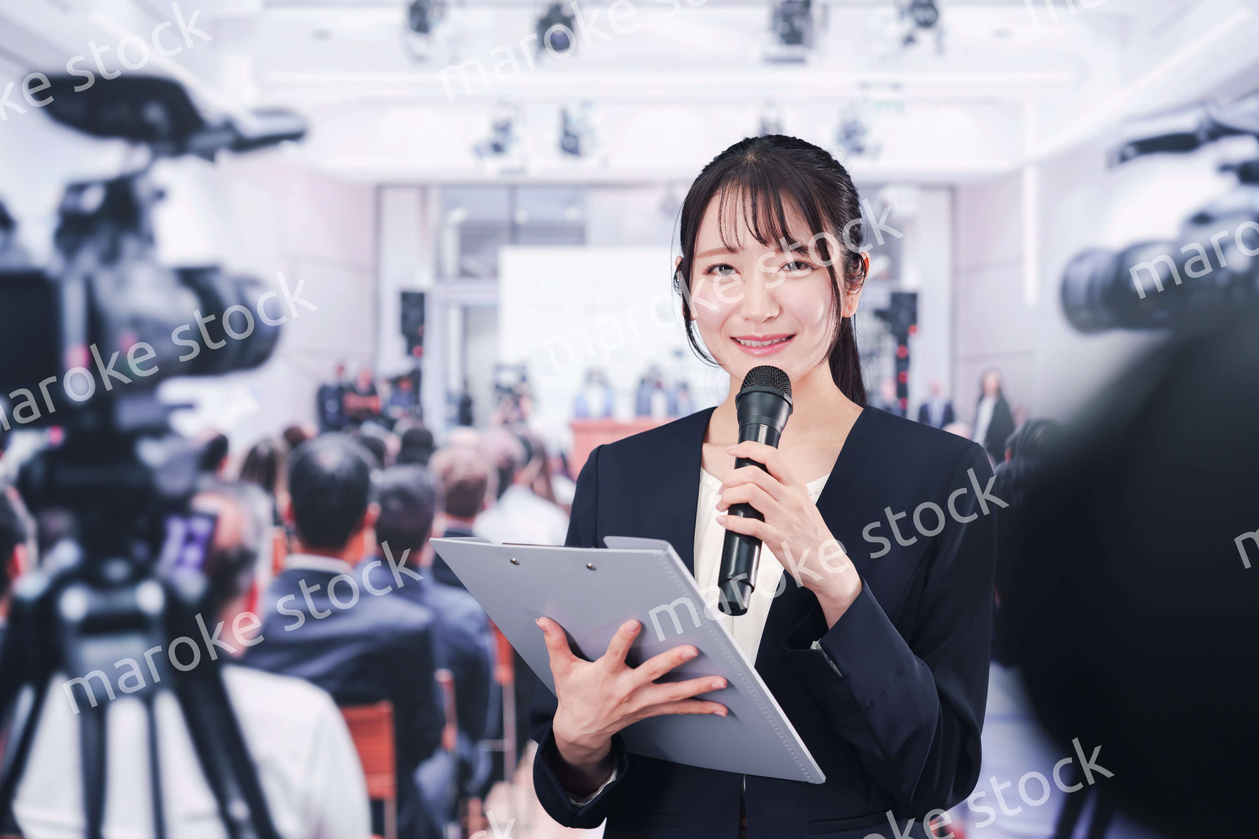 記者会見場からレポートをする女性記者