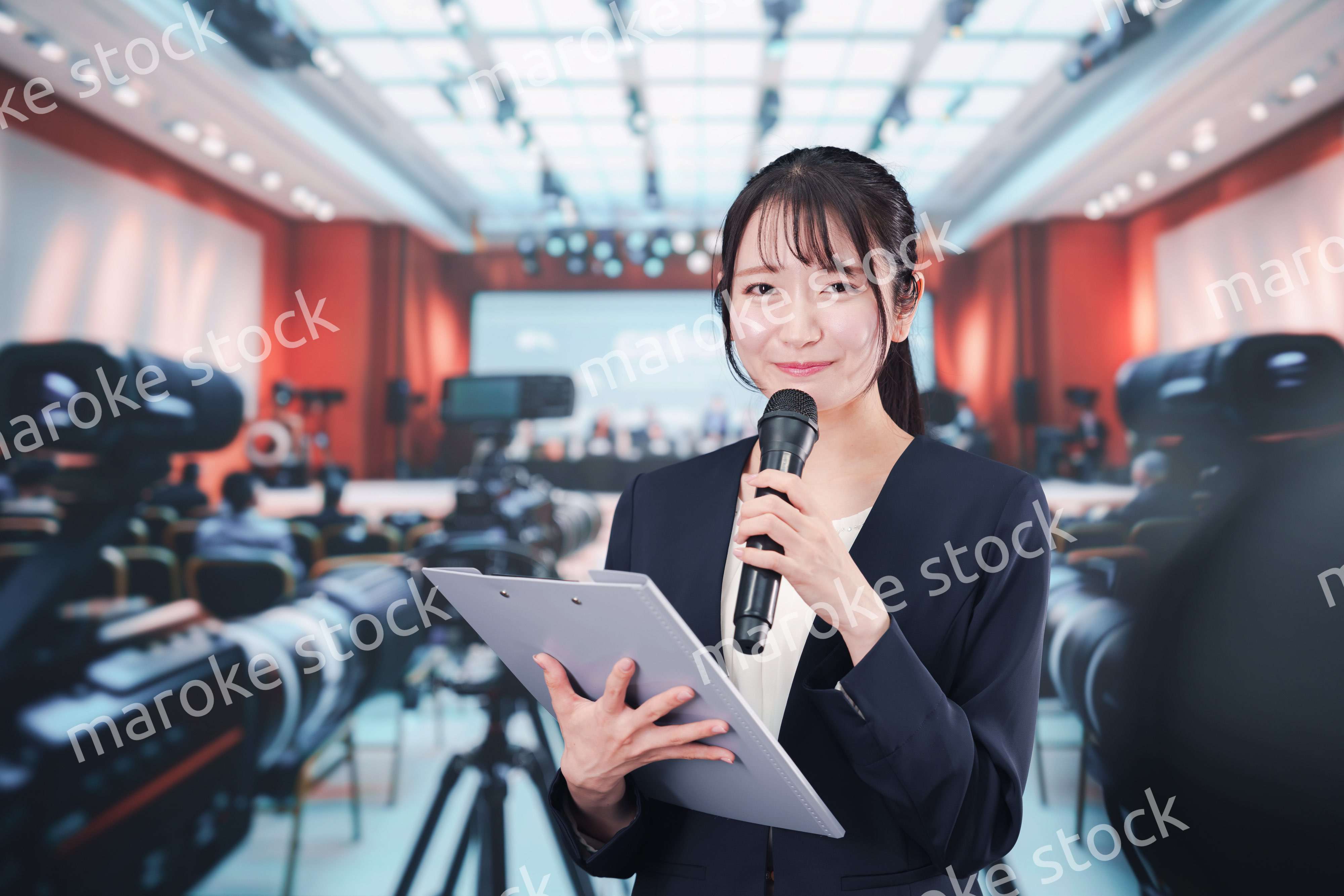 記者会見場からレポートをする女性記者