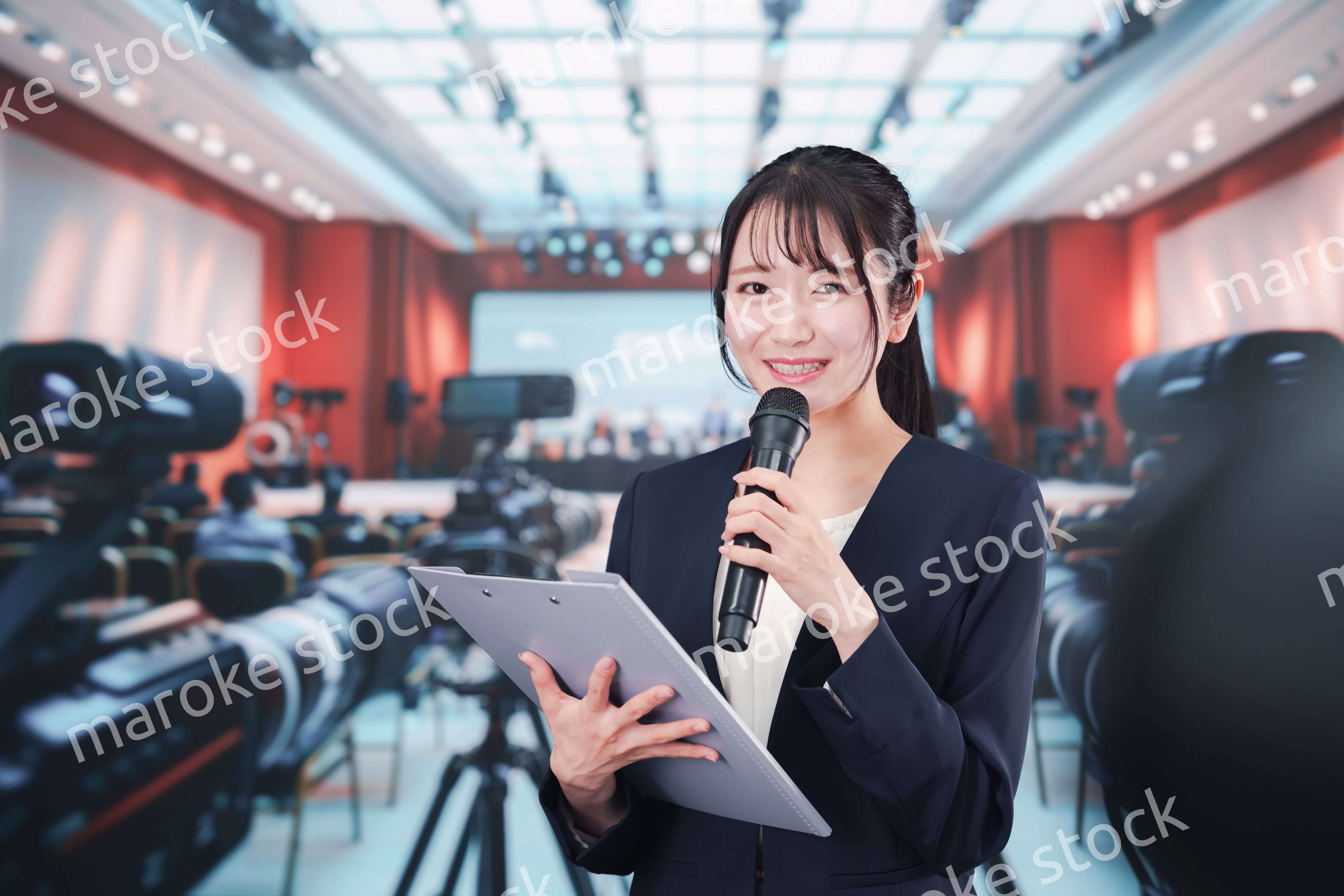 記者会見場からレポートをする女性記者