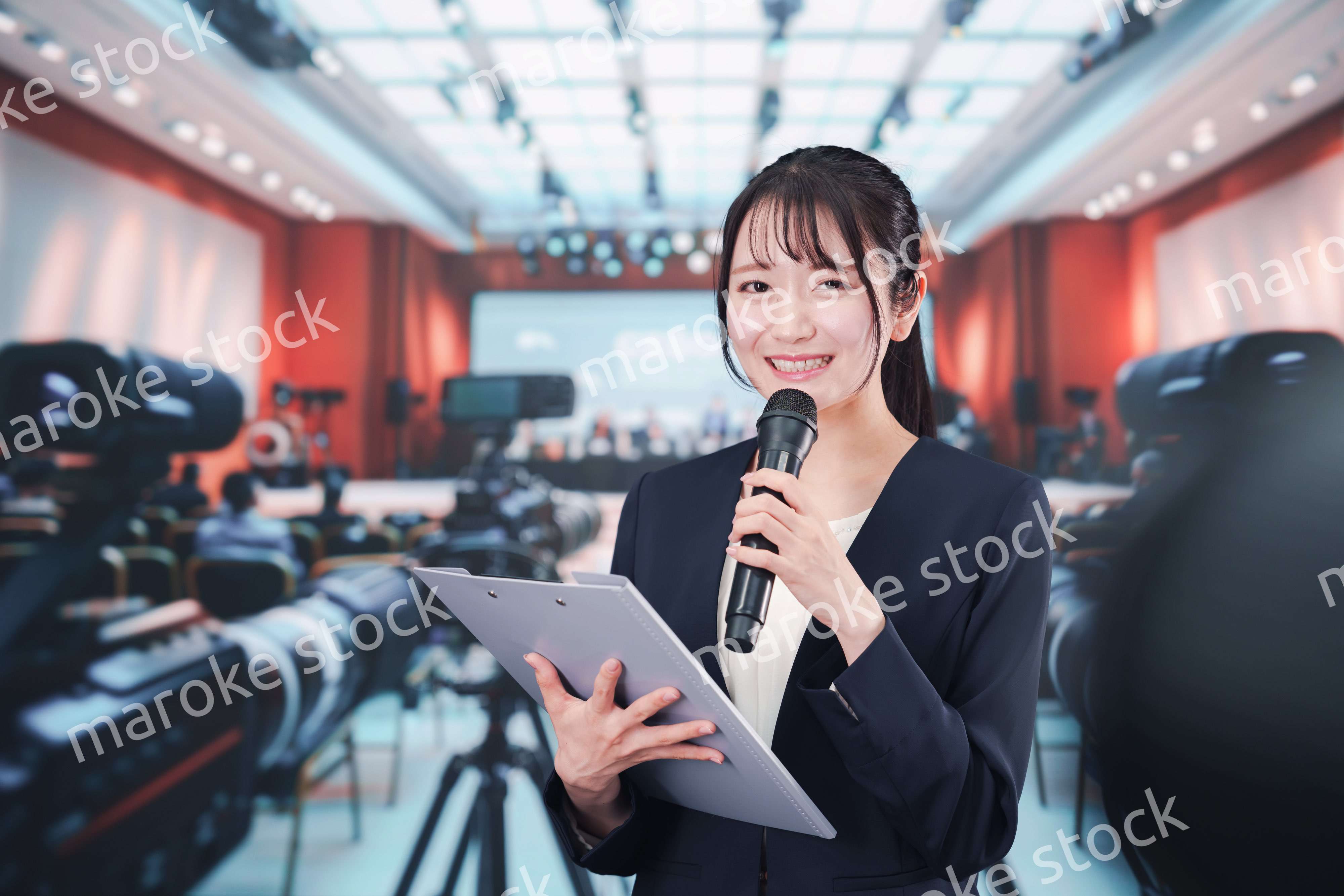 記者会見場からレポートをする女性記者